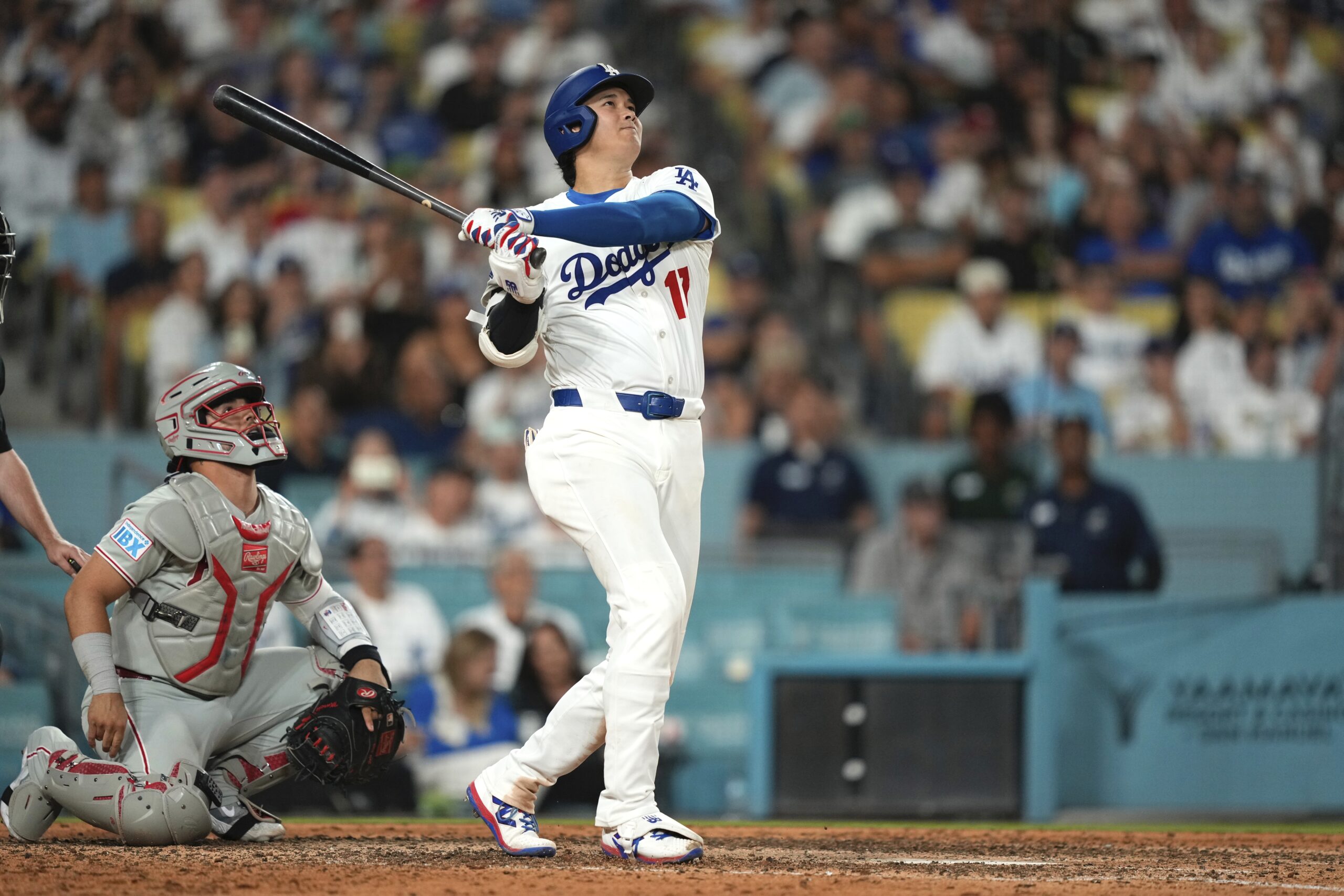 Dodgers star Shohei Ohtani watches the flight of his solo...