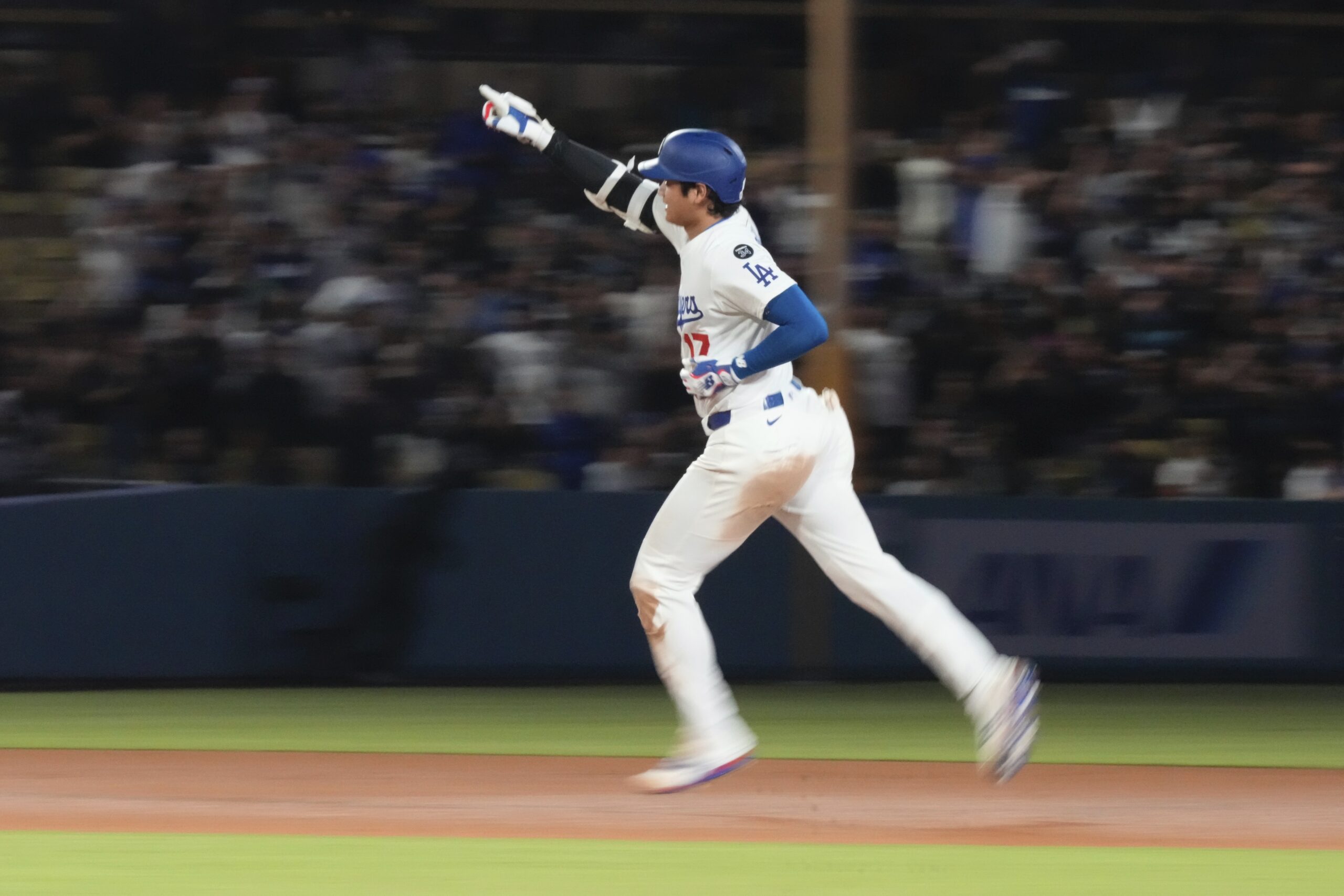Dodgers star Shohei Ohtani heads to third after hitting a...