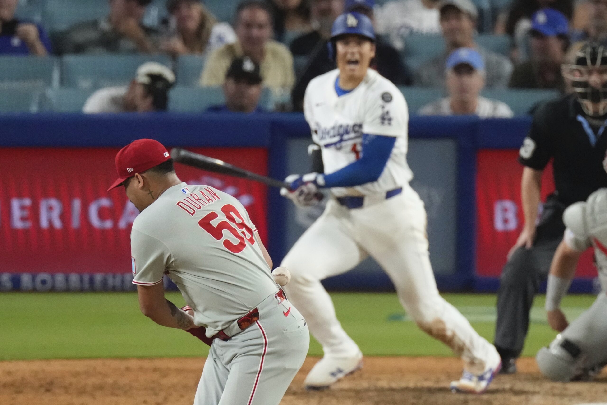 Philadelphia Phillies relief pitcher Jhoan Duran, left, deflects a ball...