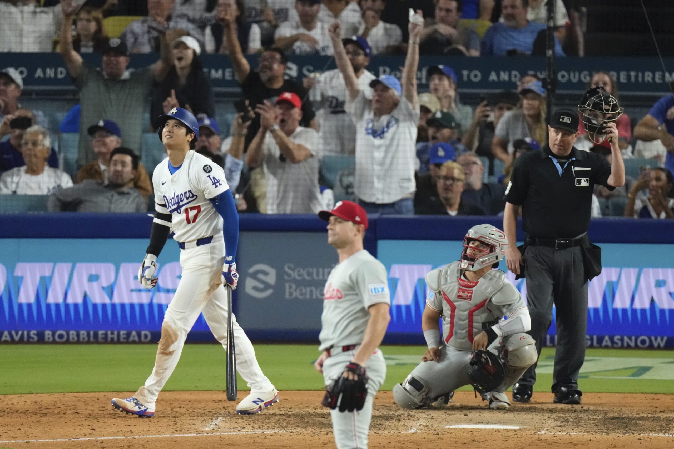 Dodgers star Shohei Ohtani, left, heads to first for a...