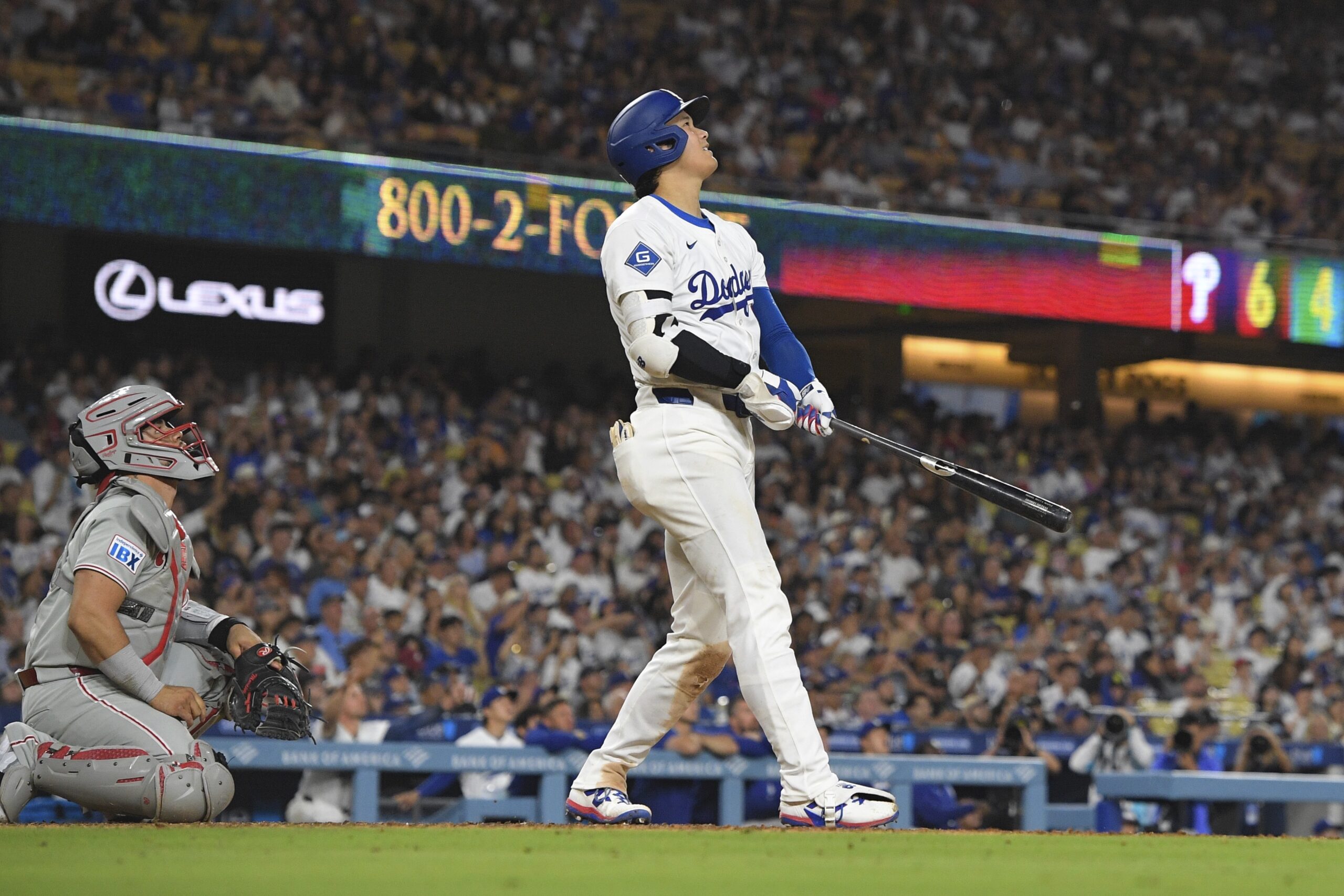 Dodgers star Shohei Ohtani, right, hits a solo home run...