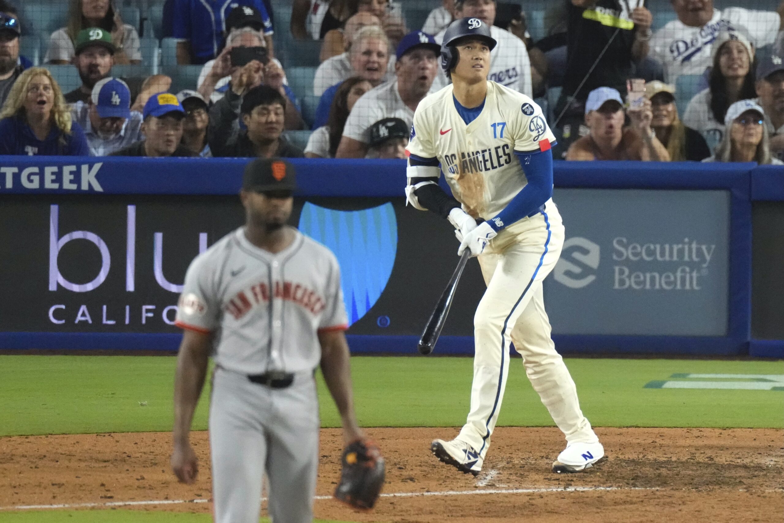 Dodgers’ Shohei Ohtani, left, heads to first for a solo...