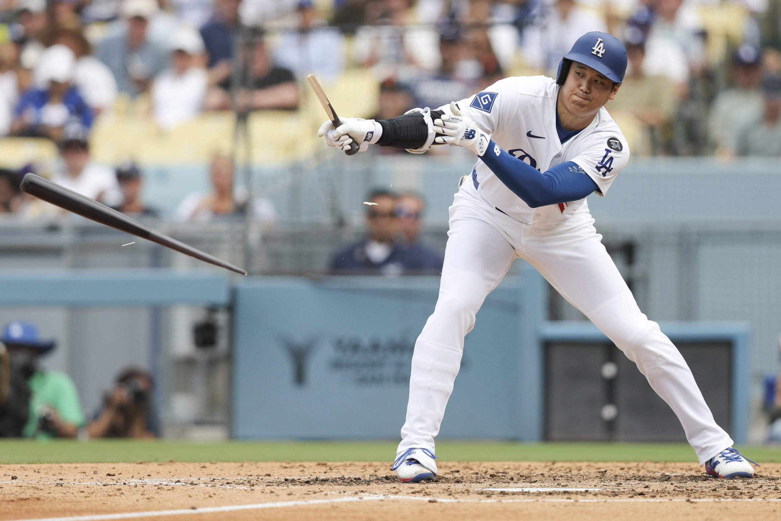 Los Angeles Dodgers designated hitter Shohei Ohtani breaks his bat...