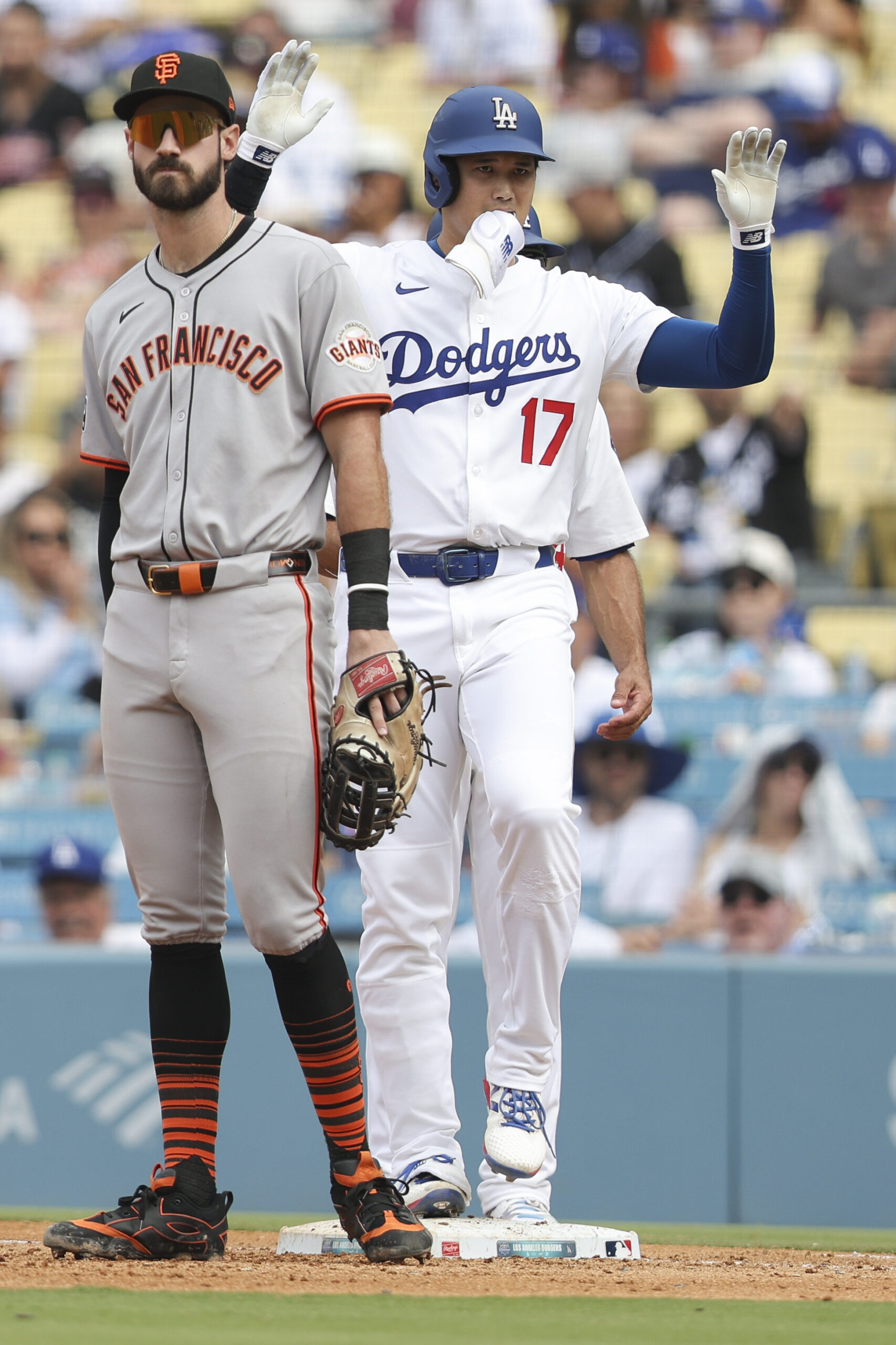 Los Angeles Dodgers designated hitter Shohei Ohtani, right, gestures after...