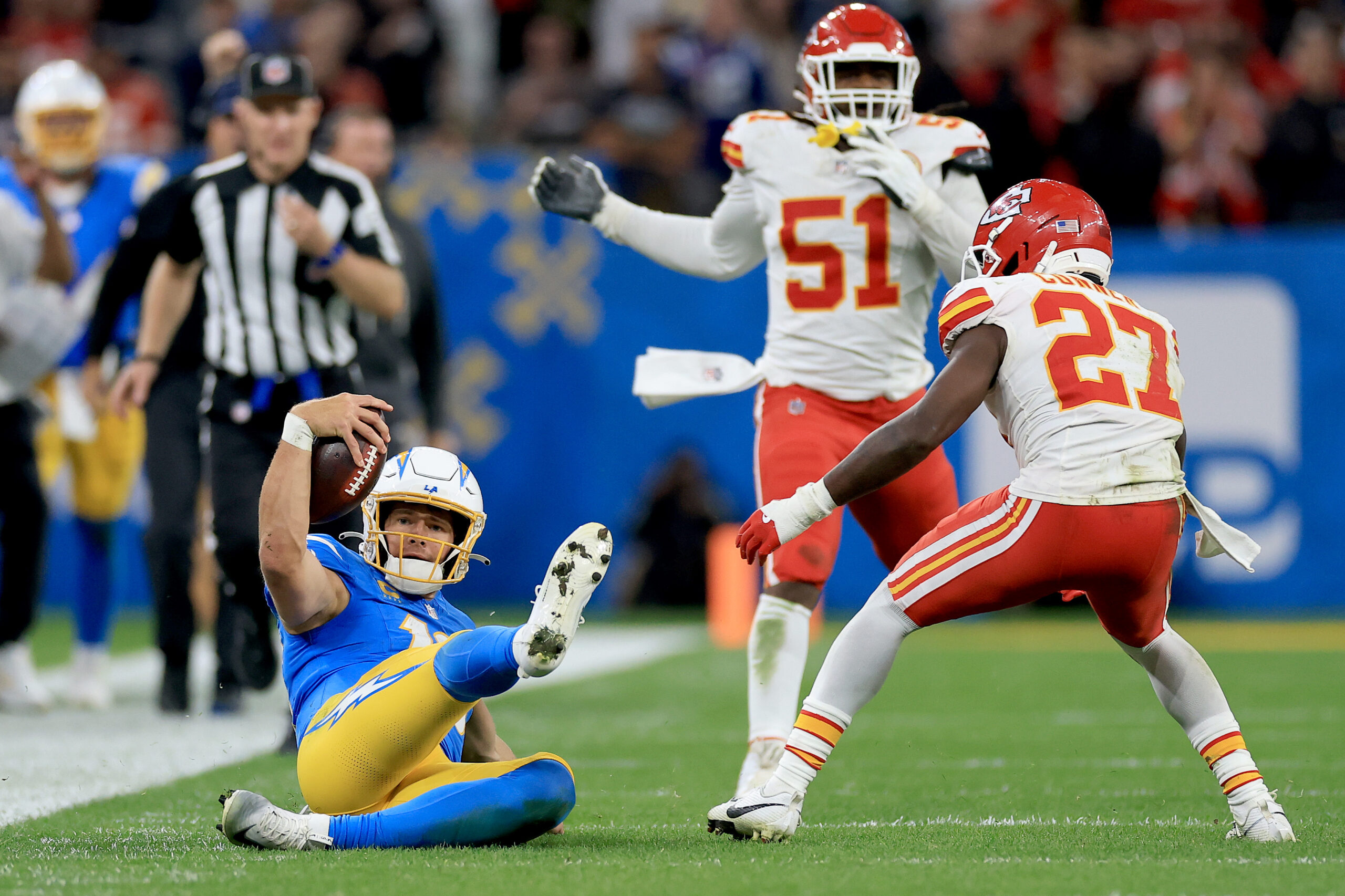 Chargers quarterback Justin Herbert slides after running for the game-clinching...