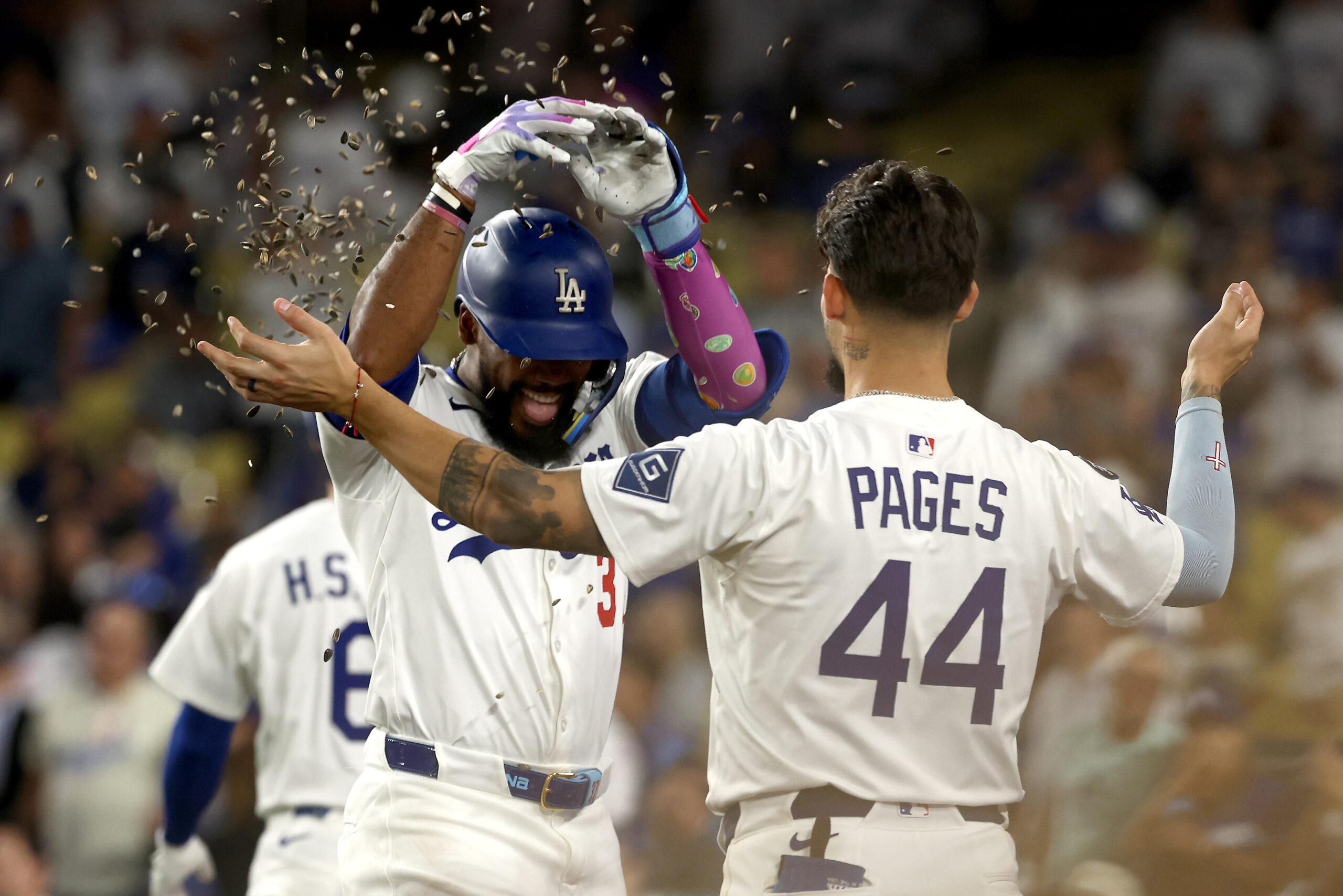 The Dodgers’ Teoscar Hernández, left, receives a sunflower seed shower...