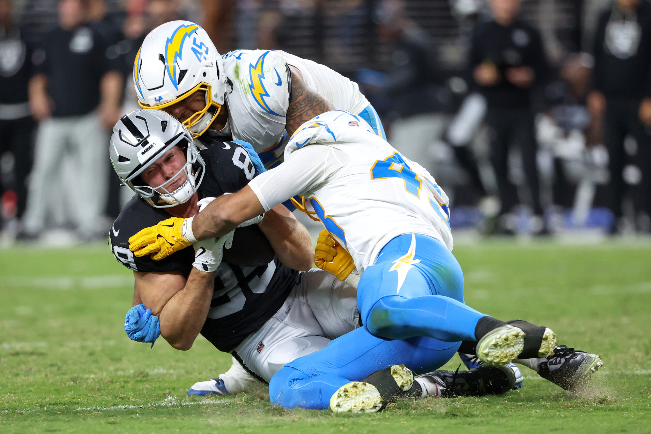 Las Vegas Raiders tight end Brock Bowers, left, is tackled...