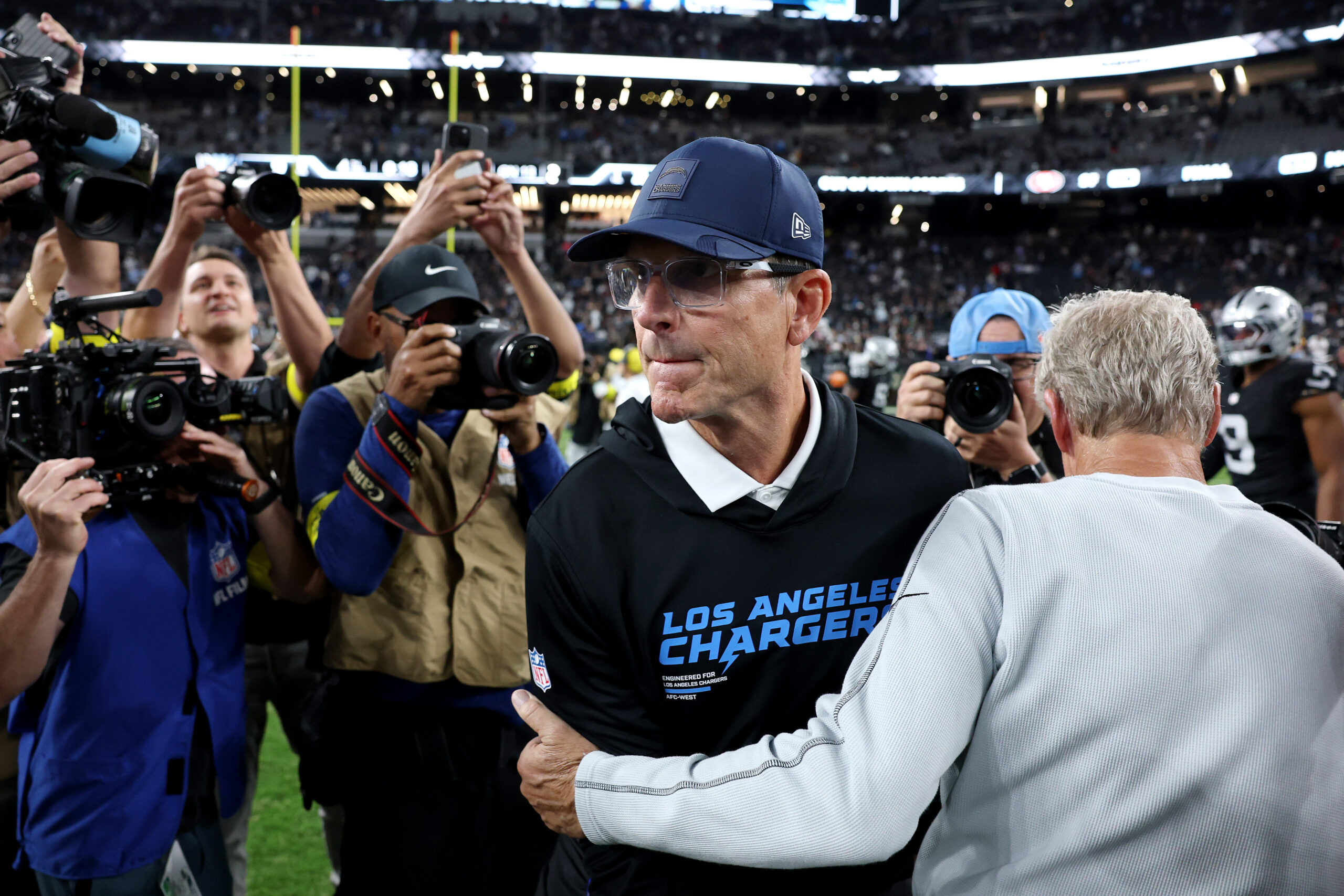 Las Vegas Raiders head coach Pete Carroll, right, shakes hands...
