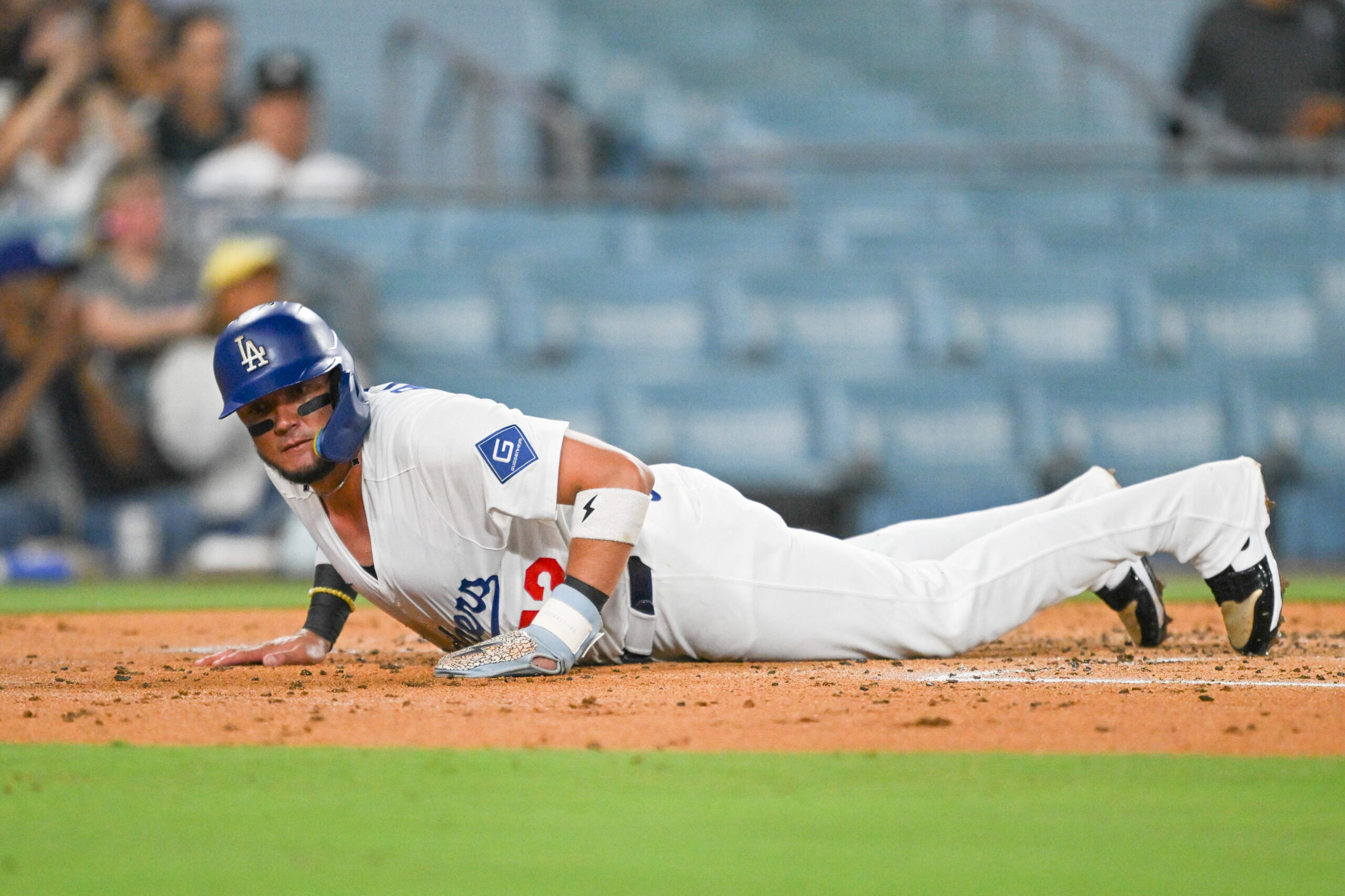 The Dodgers’ Miguel Rojas stays on the ground after sliding...