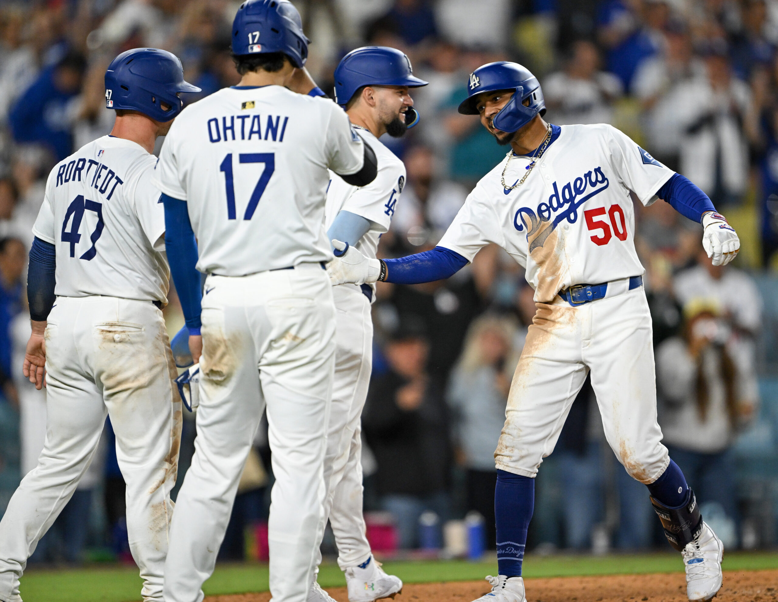 The Dodgers’ Mookie Betts, right, is greeted by teammates Shohei...