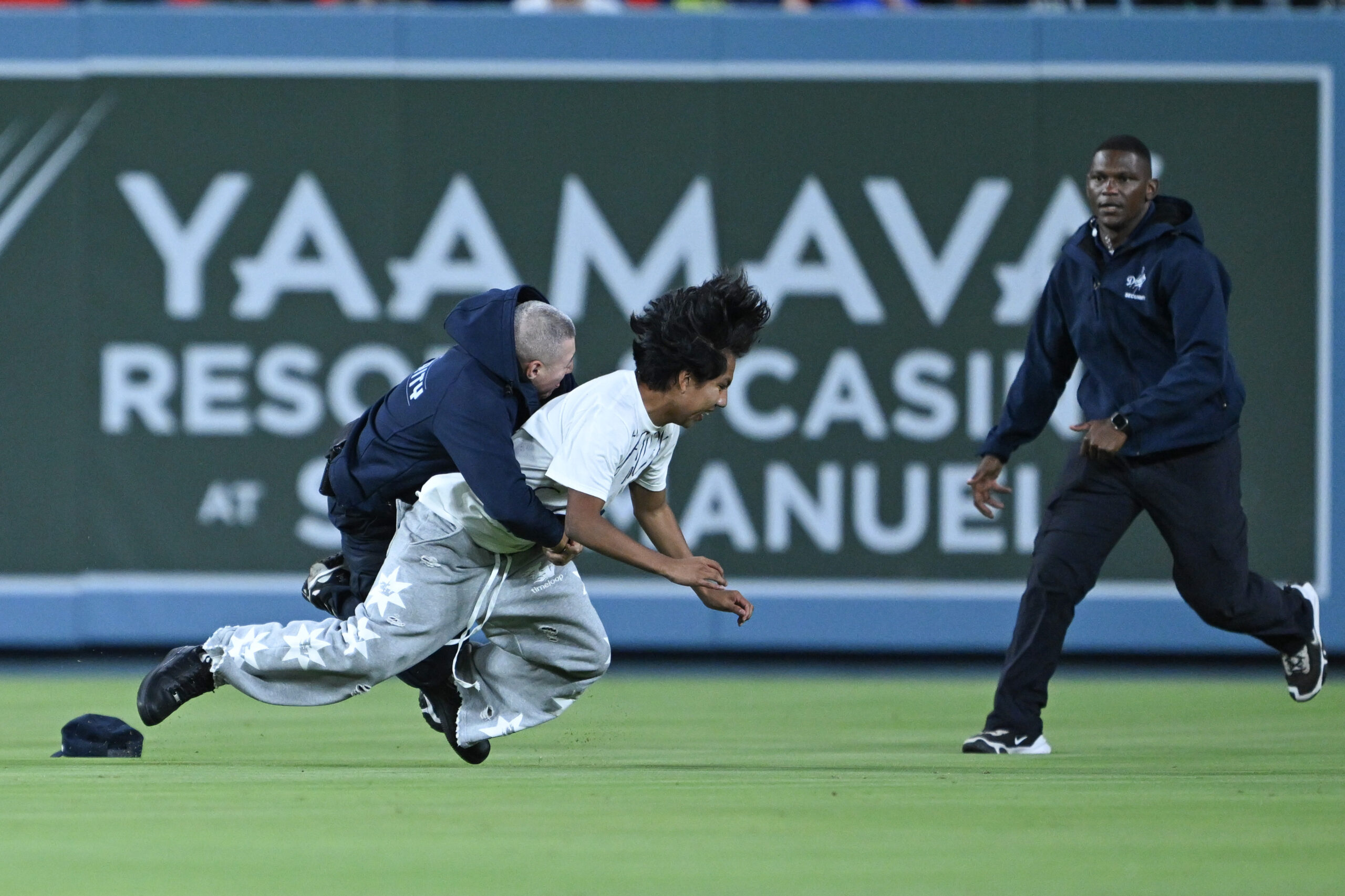 Dodgers security members had to catch a fan who managed...