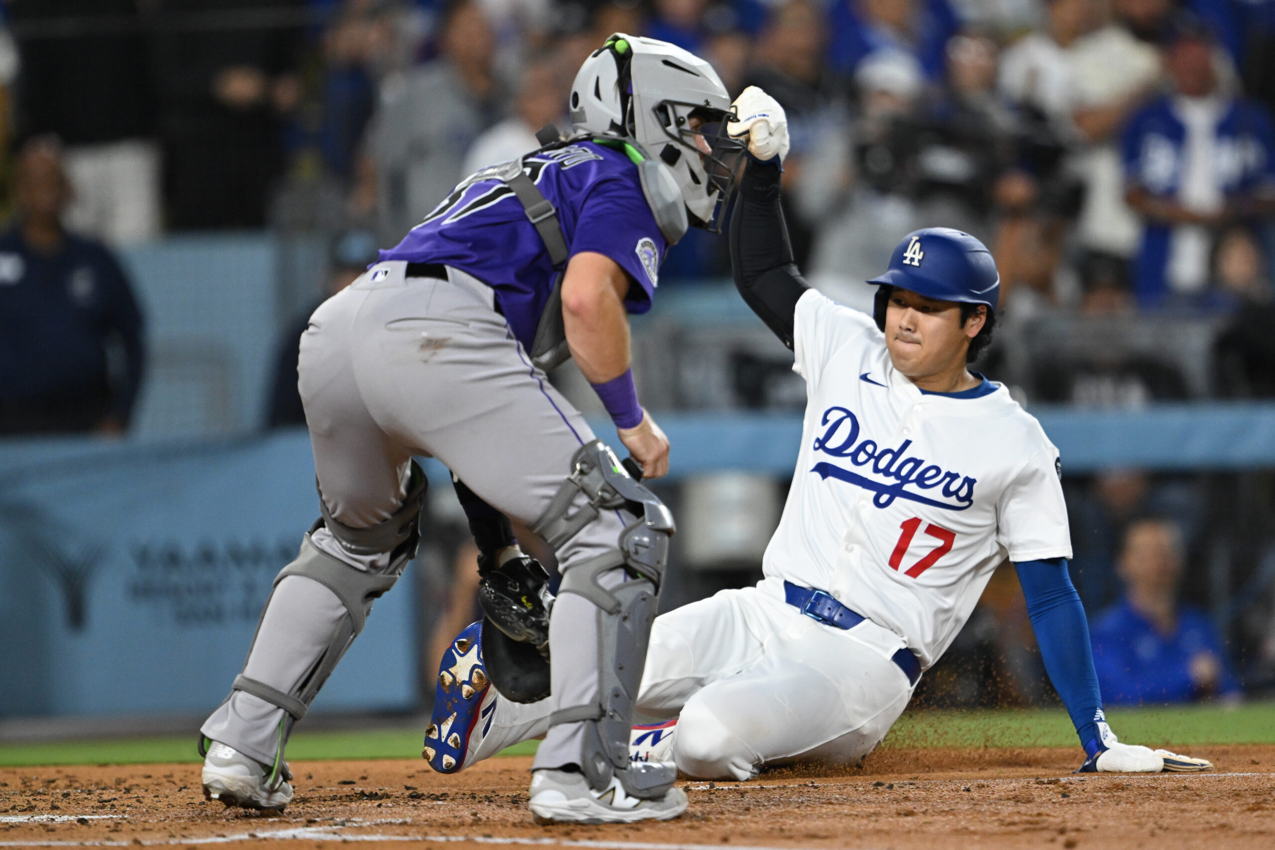 Dodgers star Shohei Ohtani, right, slides home to score on...