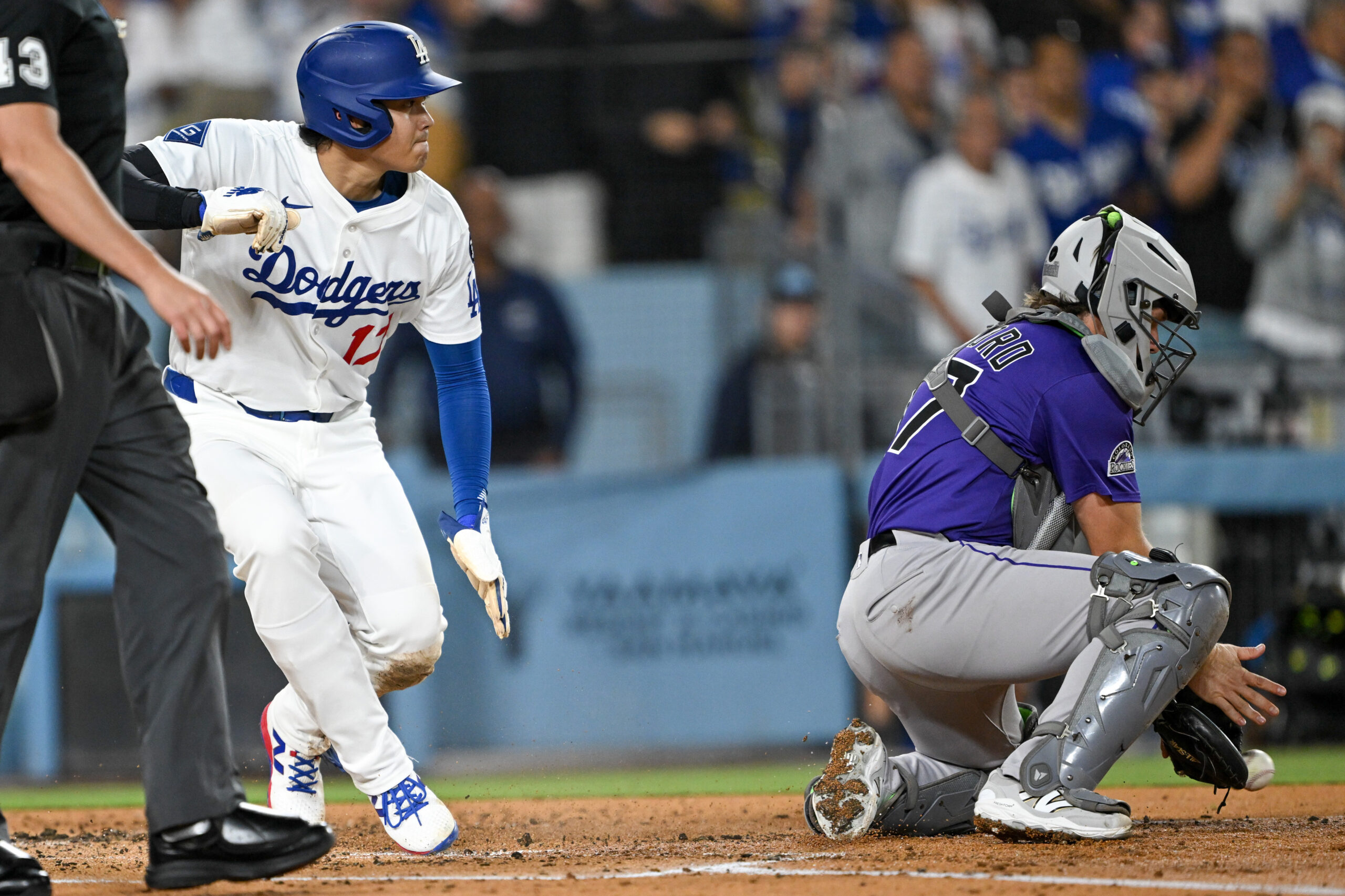 Dodgers star Shohei Ohtani, left, scores on a double by...