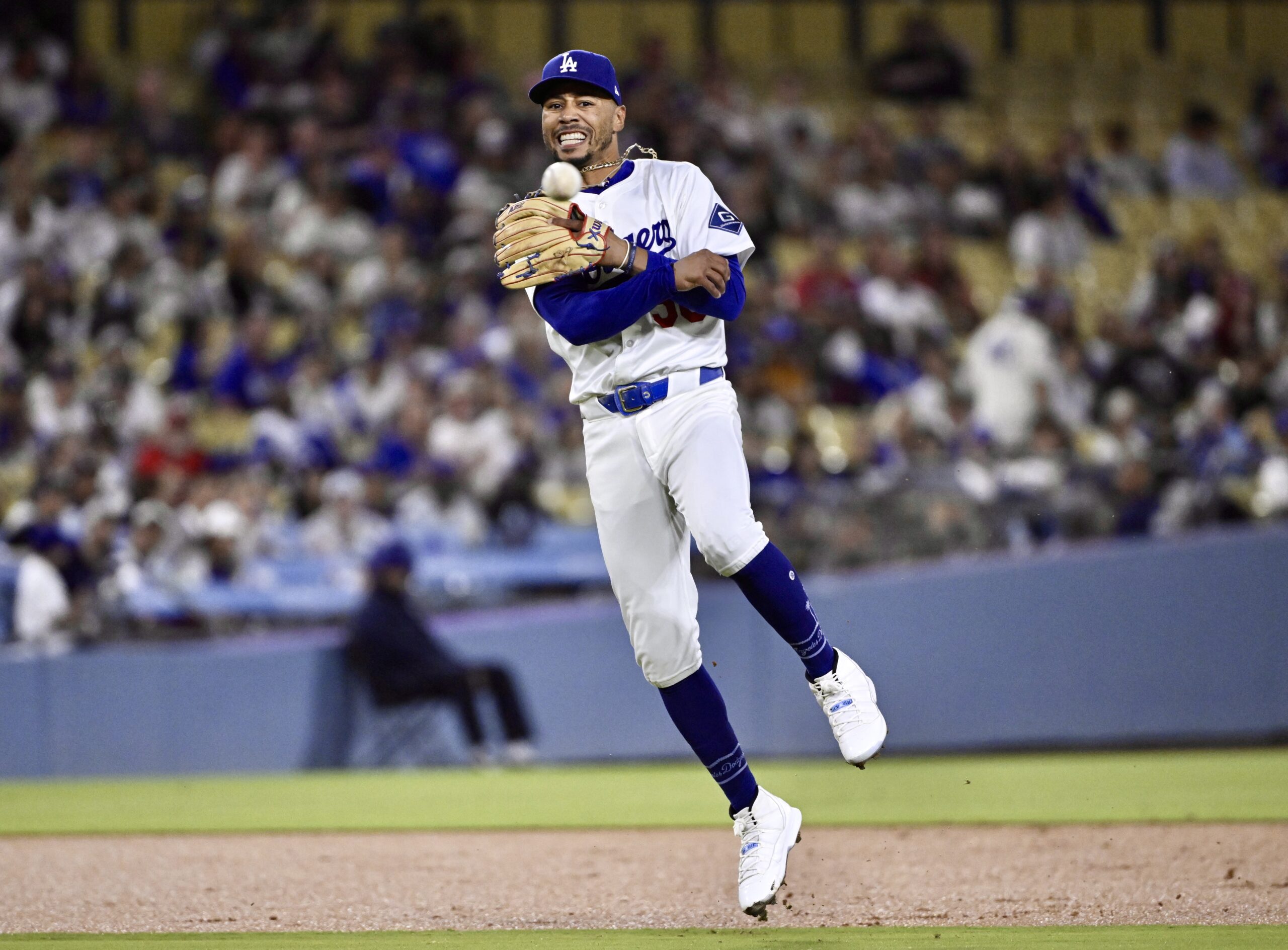 Dodgers shortstop Mookie Betts throws to first base to force...