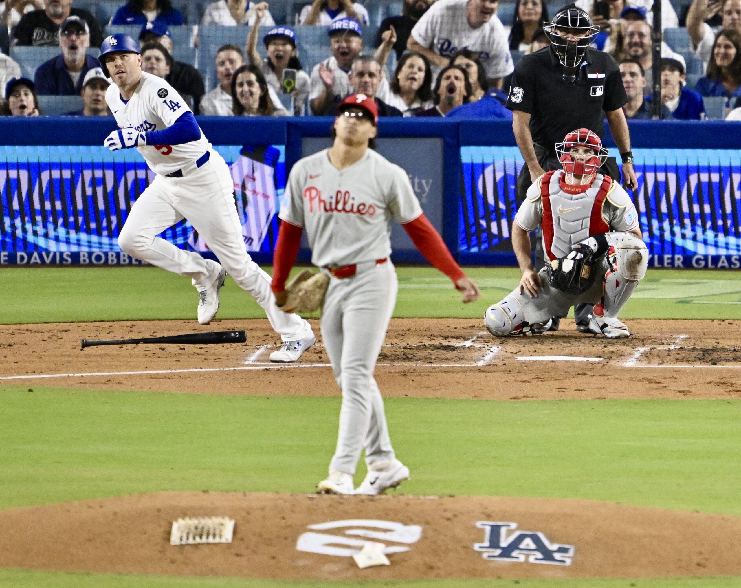 The Dodgers’ Freddie Freeman, left, begins to run the bases...