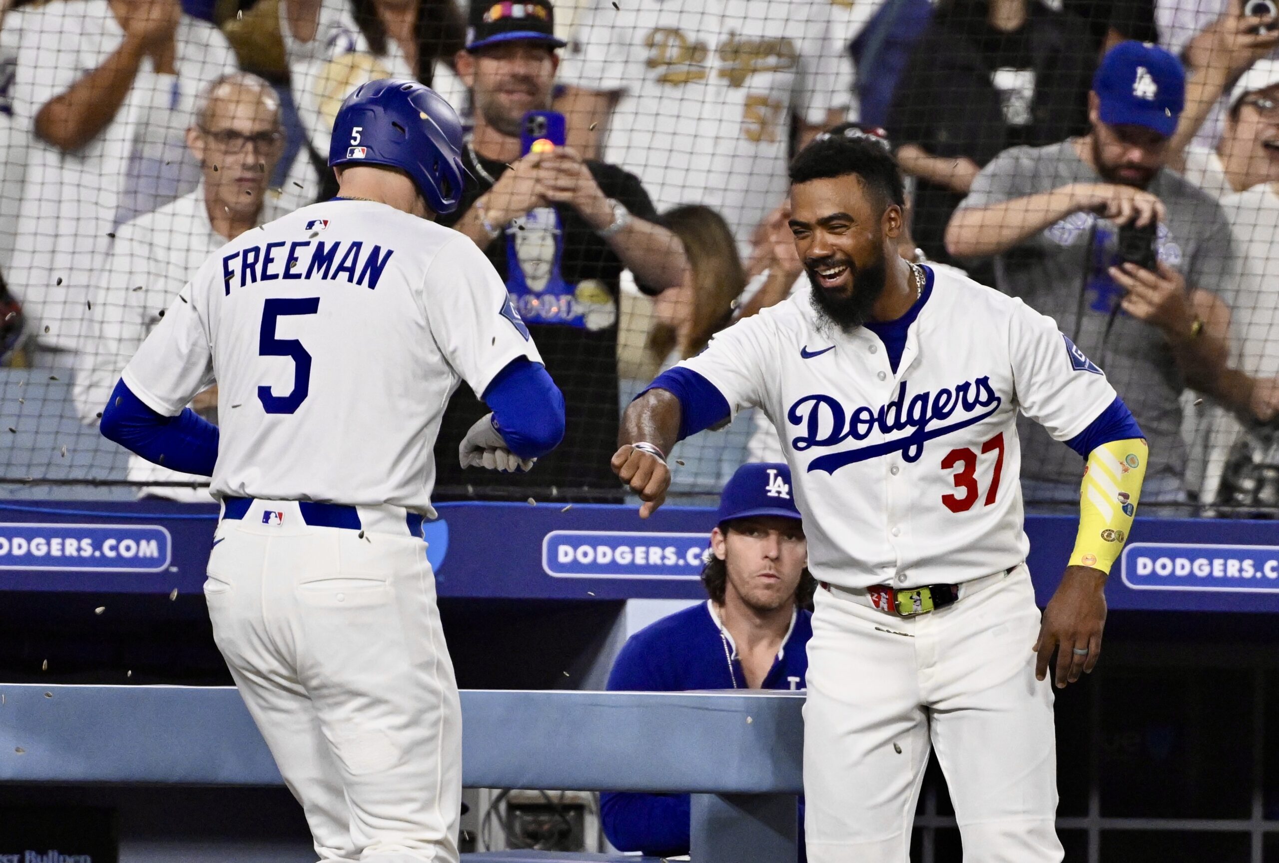 The Dodgers’ Freddie Freeman, left, is showered with sunflower seeds...