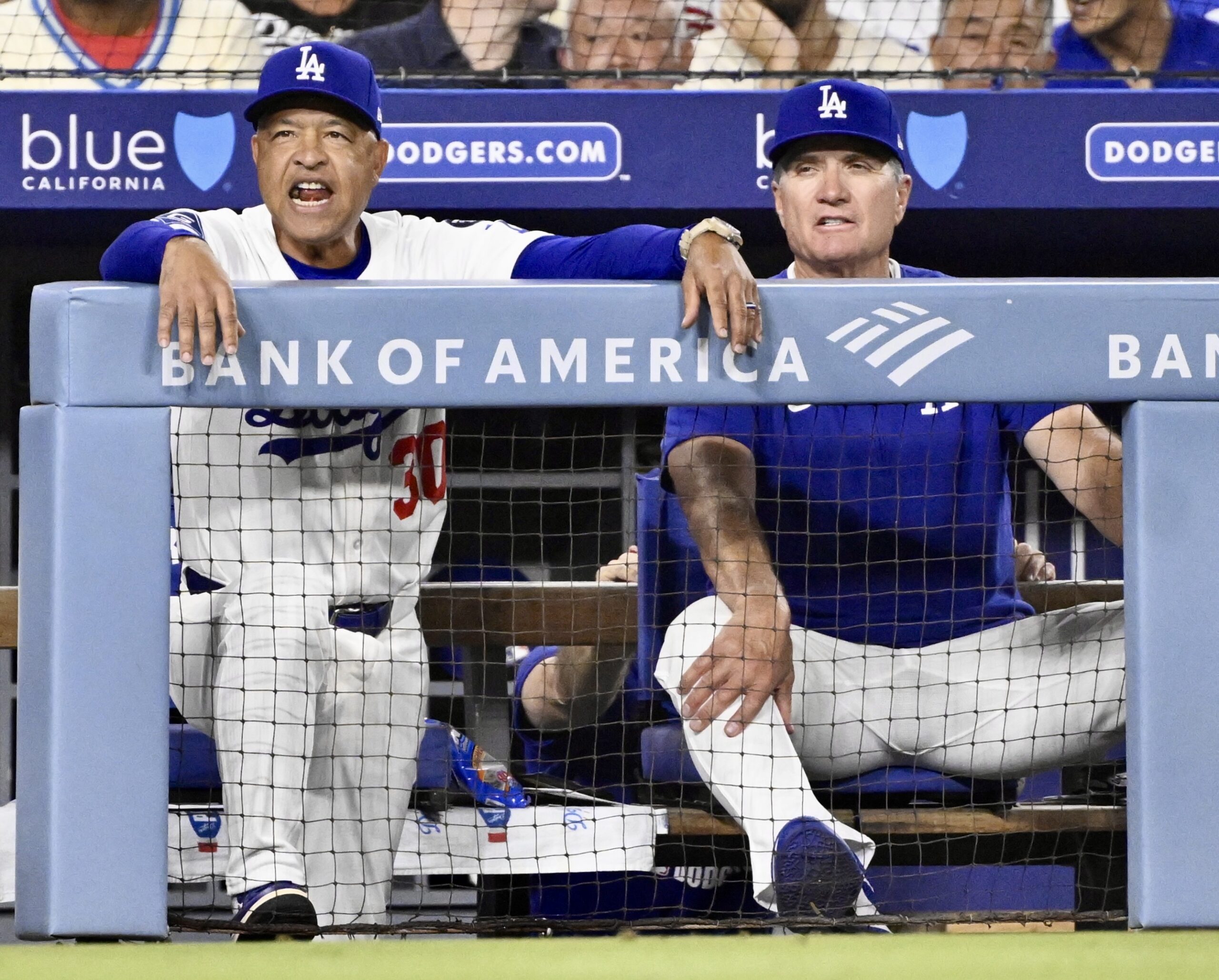 Dodgers manager Dave Roberts, left, reacts toward home plate as...