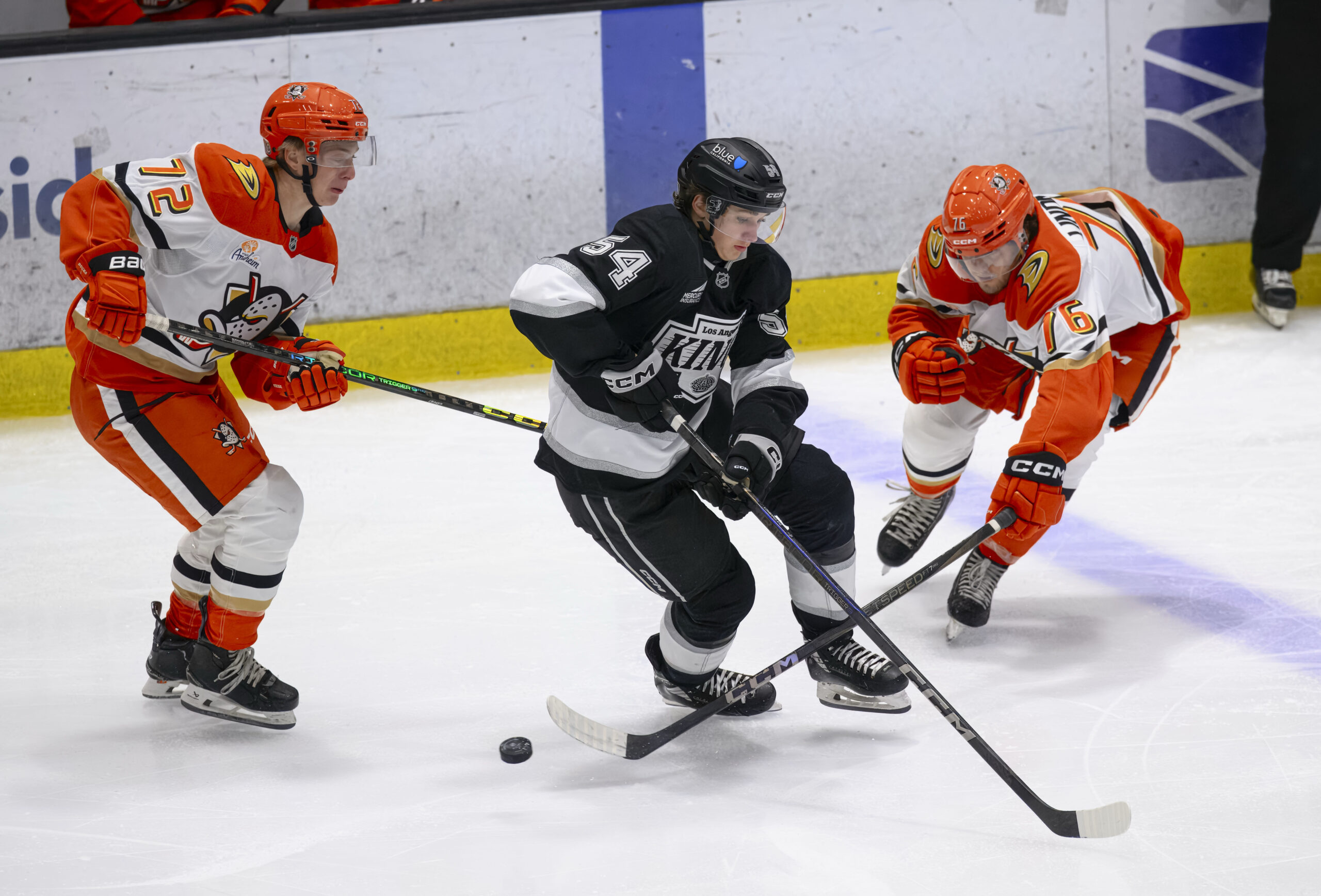 The Ducks’ Owen Lindmark, right, slaps the puck away from...