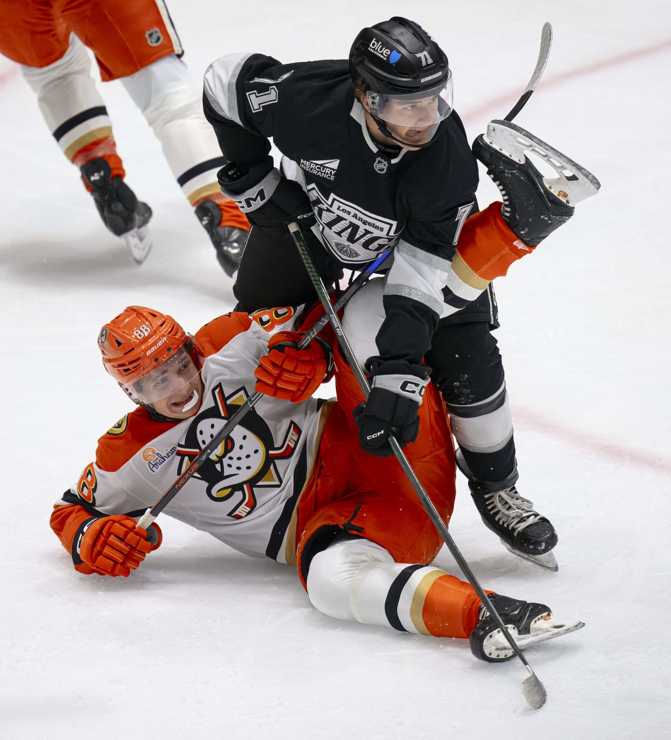 The Ducks’ Darels Uljanskis, left, falls as the Kings’ Ryan...