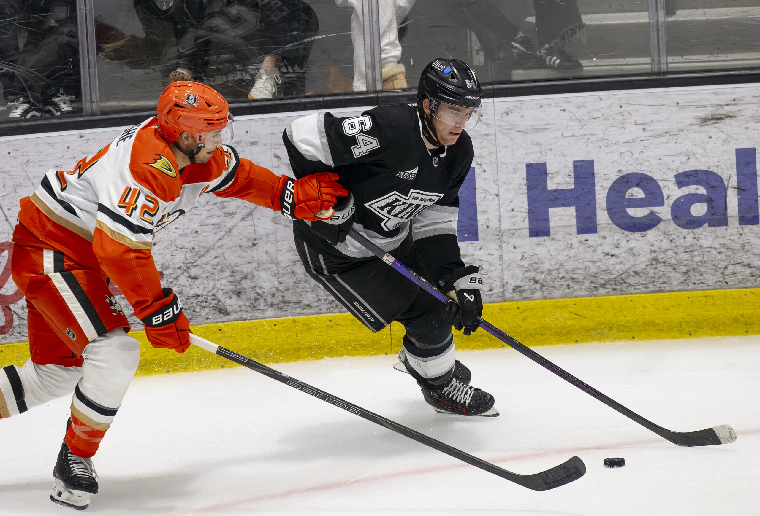 The Kings’ Liam Greentree, right, moves the puck away from...