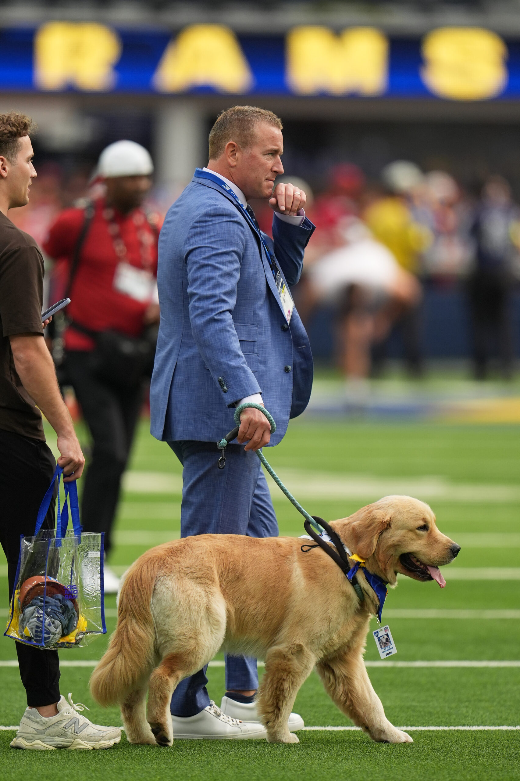 Broadcaster Kirk Herbstreit walks on the field with his dog...