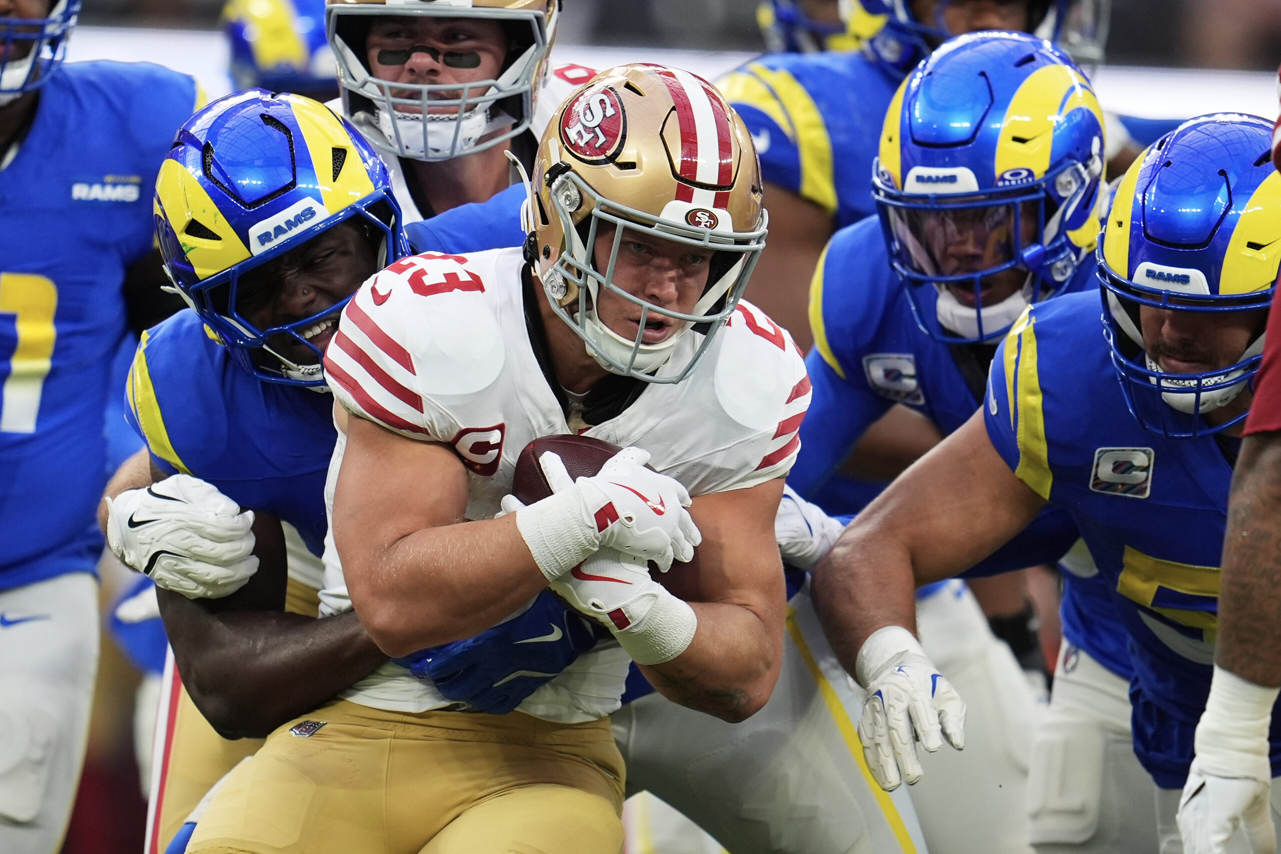 San Francisco 49ers running back Christian McCaffrey, middle, is tackled...