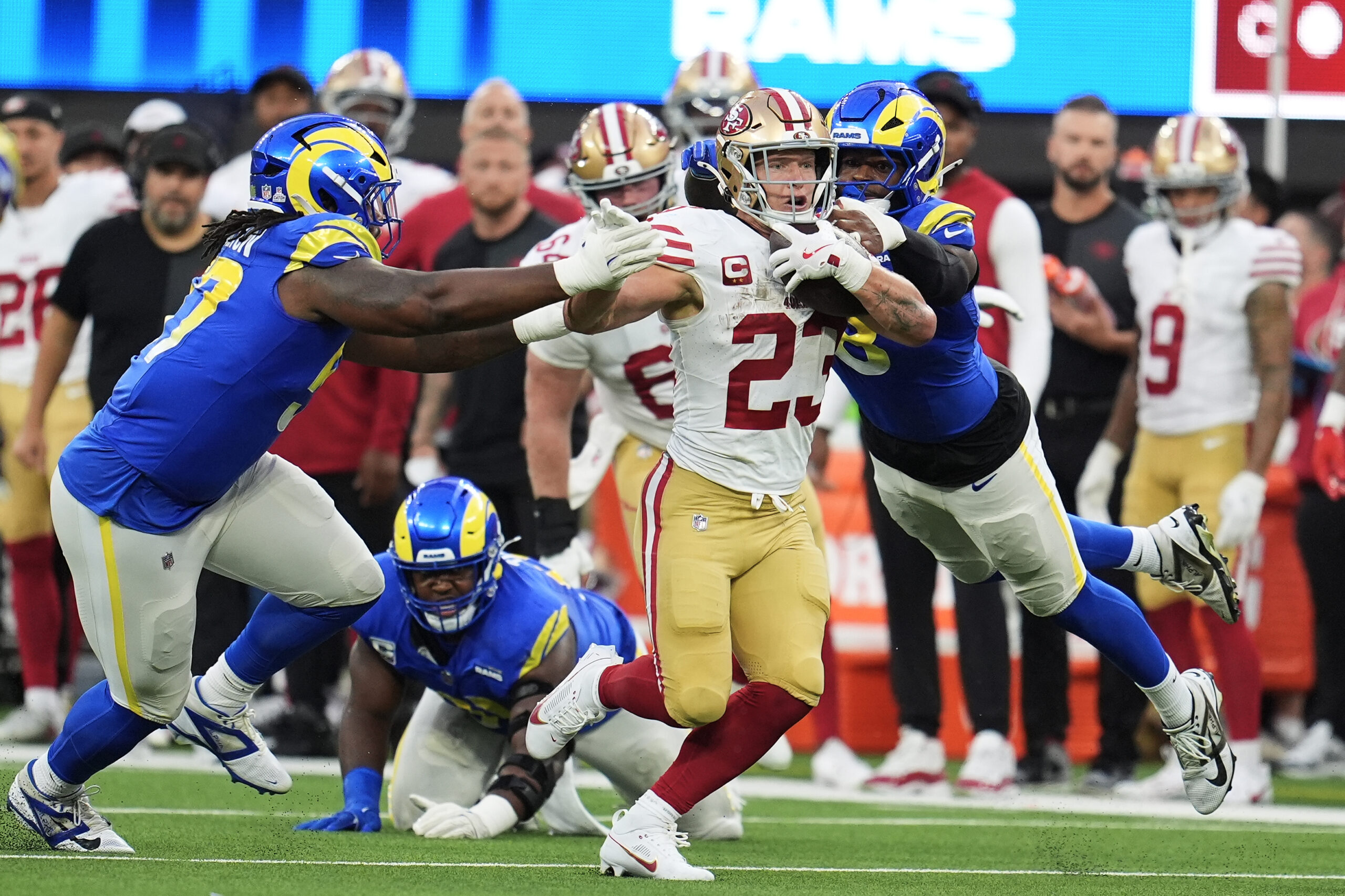 San Francisco 49ers running back Christian McCaffrey, middle, runs against...