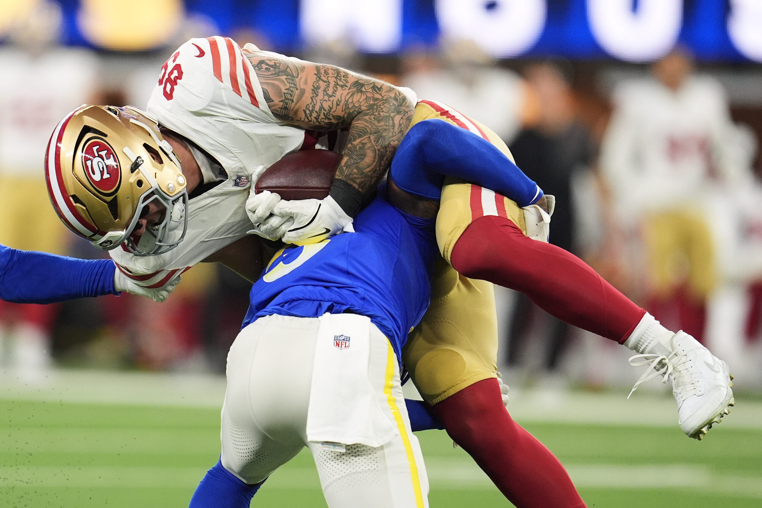 San Francisco 49ers tight end Luke Farrell, top, is tackled...
