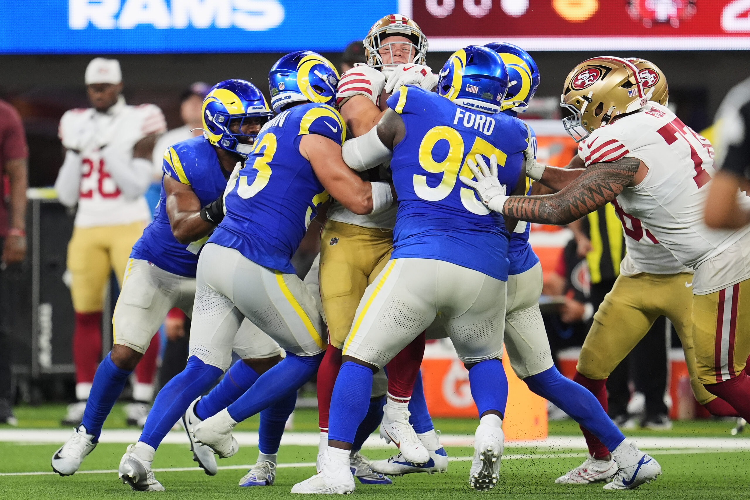 San Francisco 49ers running back Christian McCaffrey, middle, is tackled...