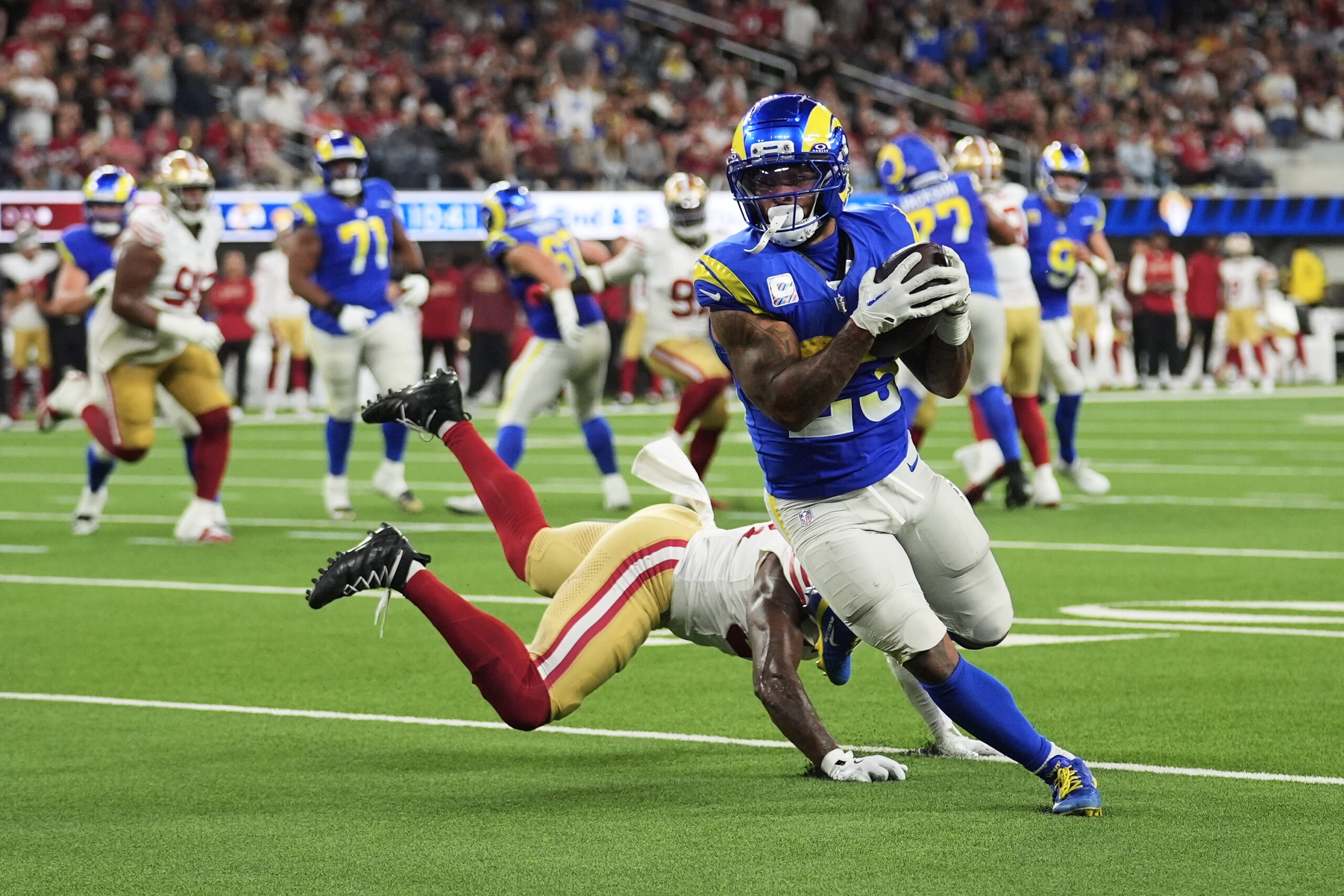Rams running back Kyren Williams, right, runs past San Francisco...