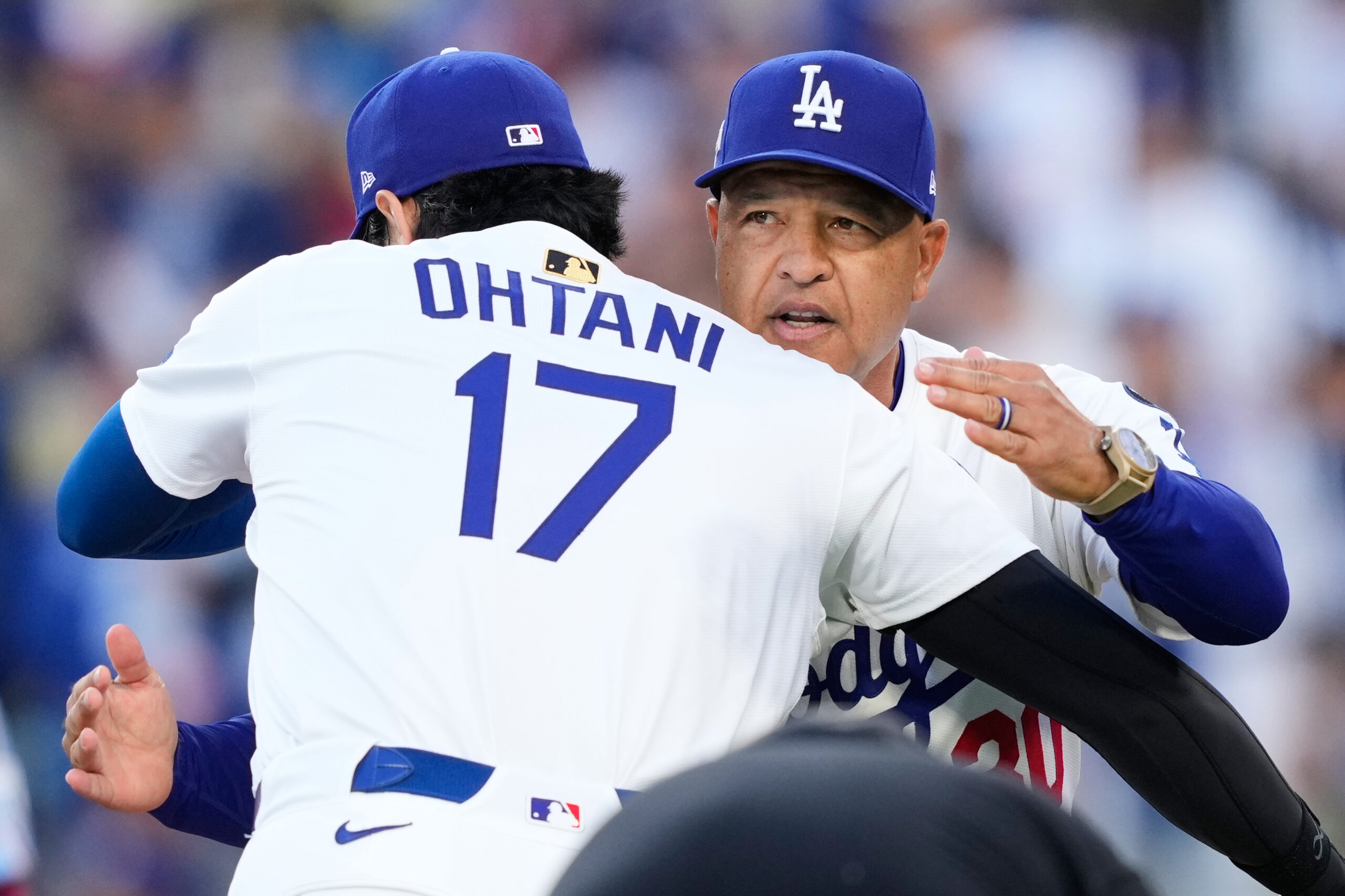 Dodgers star Shohei Ohtani gets a hug from Manager Dave...
