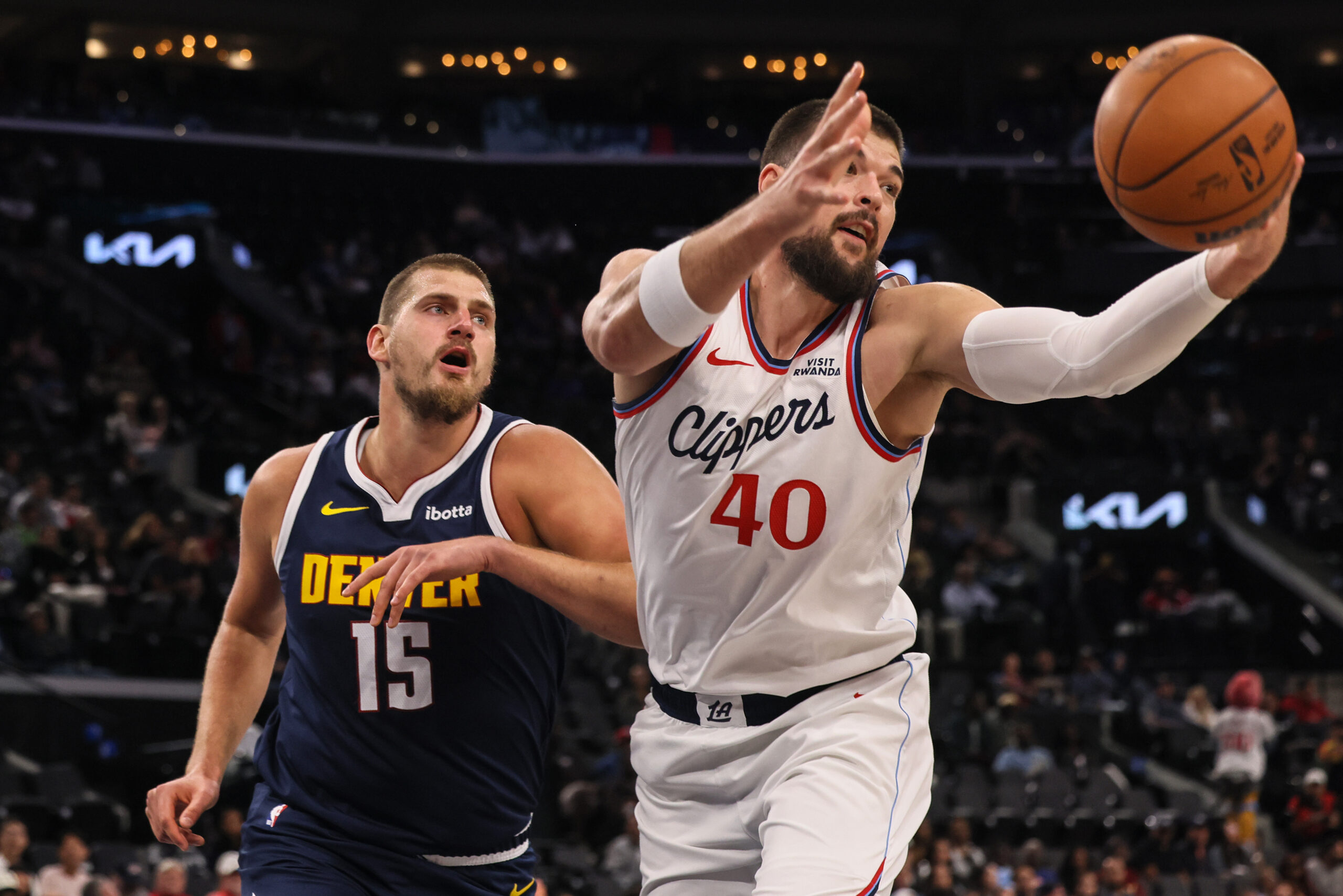 Clippers center Ivica Zubac, right, captures a rebound against Denver...
