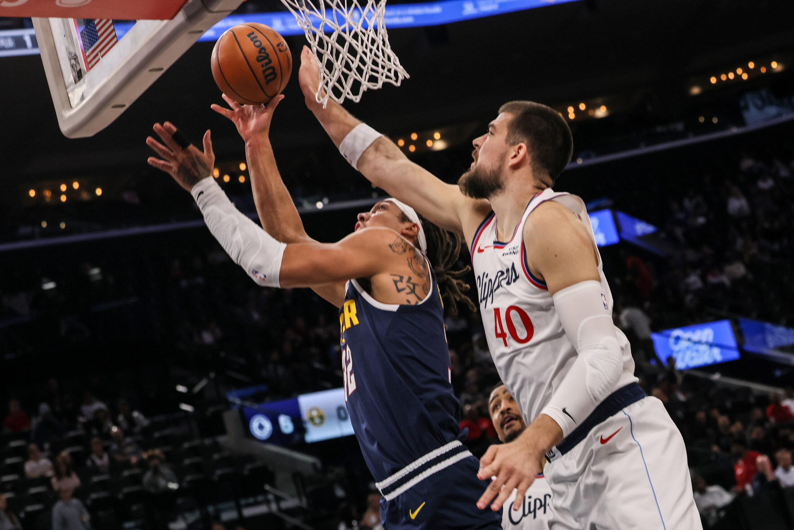 Denver Nuggets forward Aaron Gordon, left, scores against Clippers center...