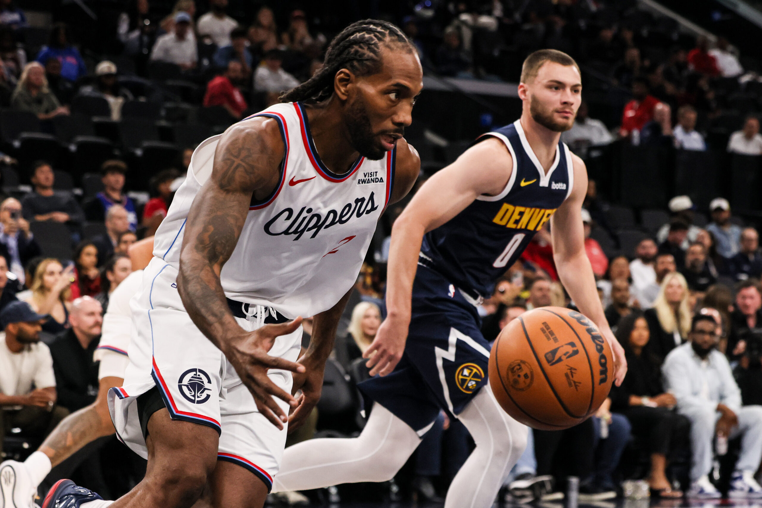Clippers forward Kawhi Leonard, left, captures a rebound against Denver...