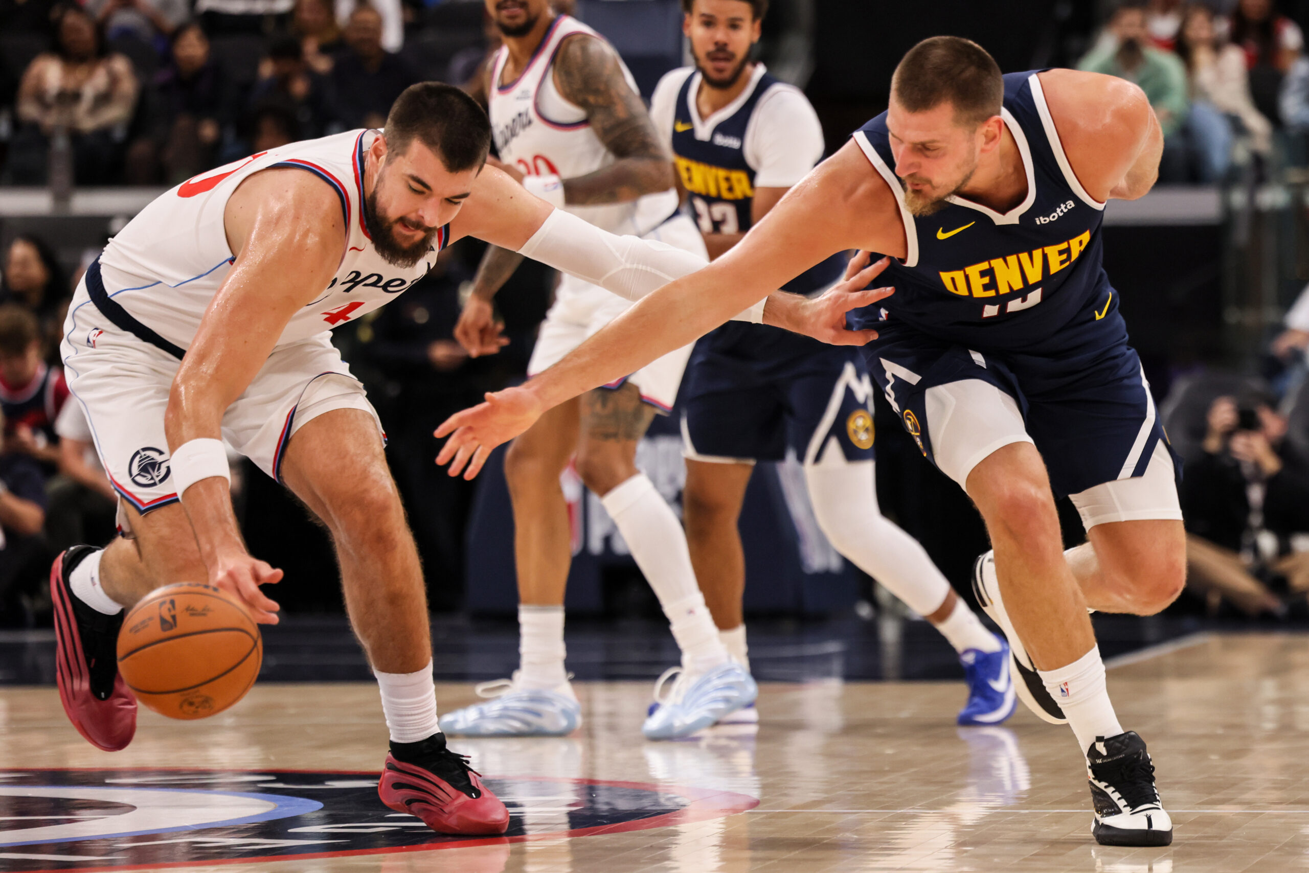 Clippers center Ivica Zubac, left, goes for the ball against...