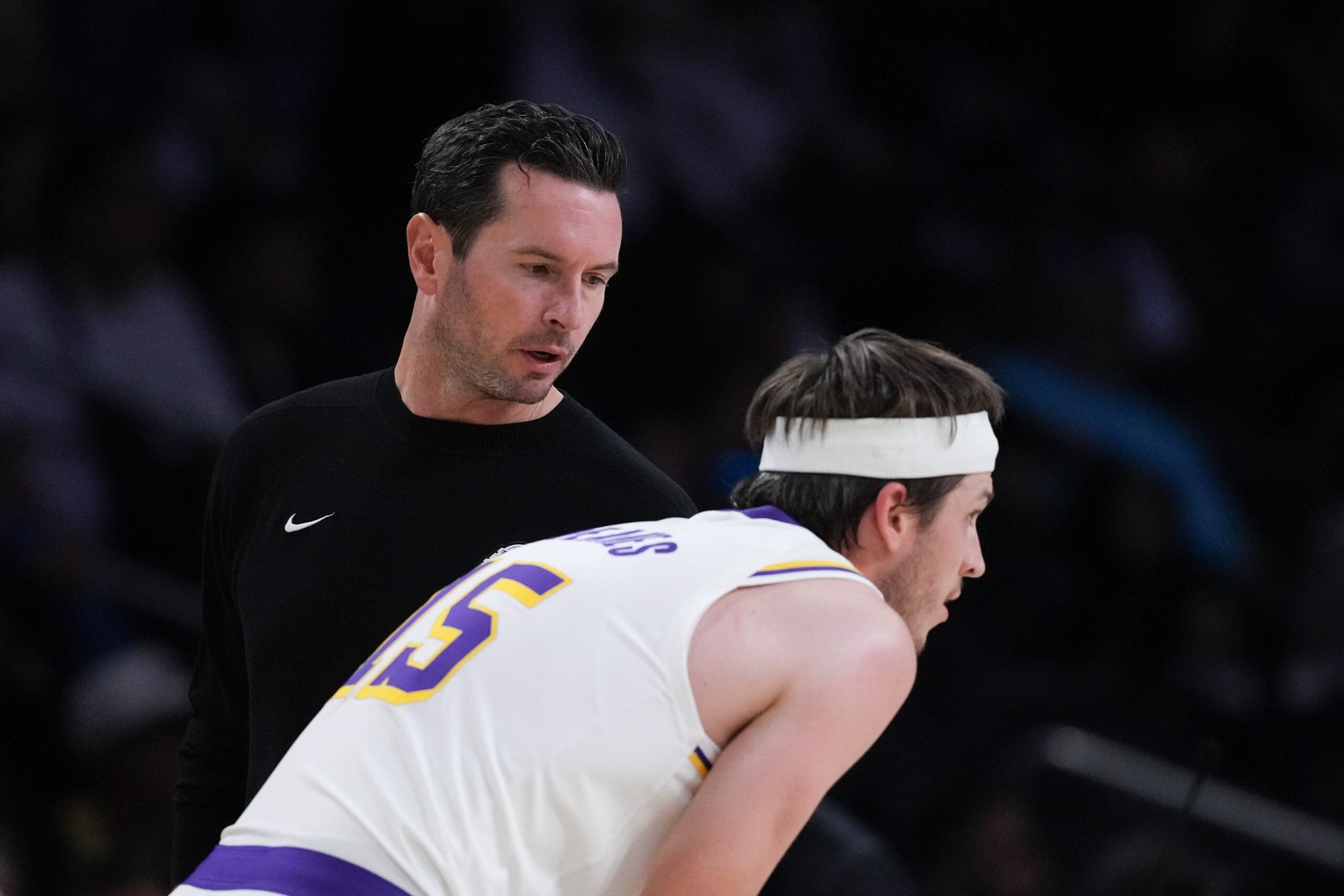 Lakers head coach JJ Redick talks to guard Austin Reaves...