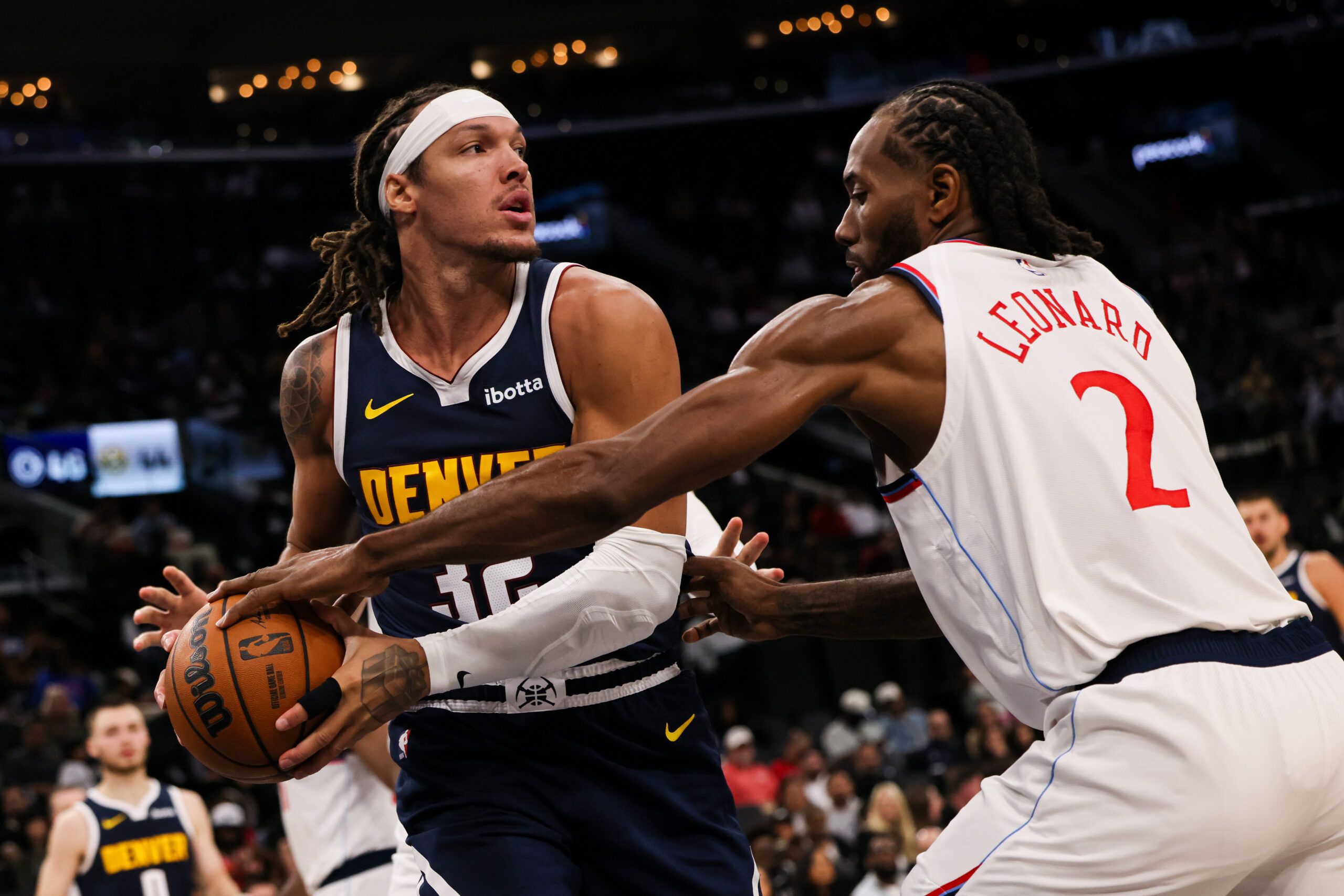 Denver Nuggets forward Aaron Gordon, left, dribbles past Clippers forward...
