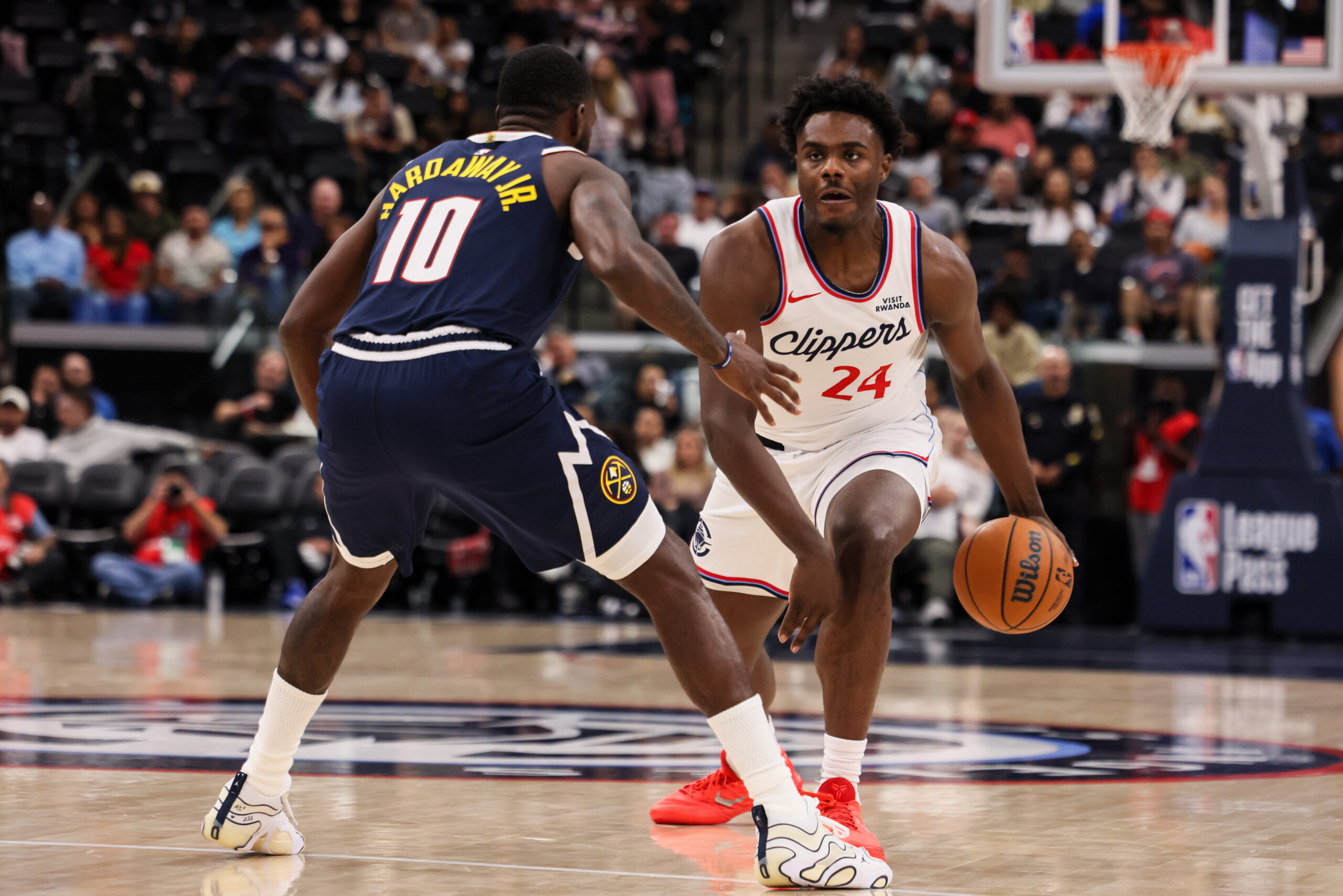 Clippers forward Kobe Brown, right, dribbles past Denver Nuggets guard-forward...