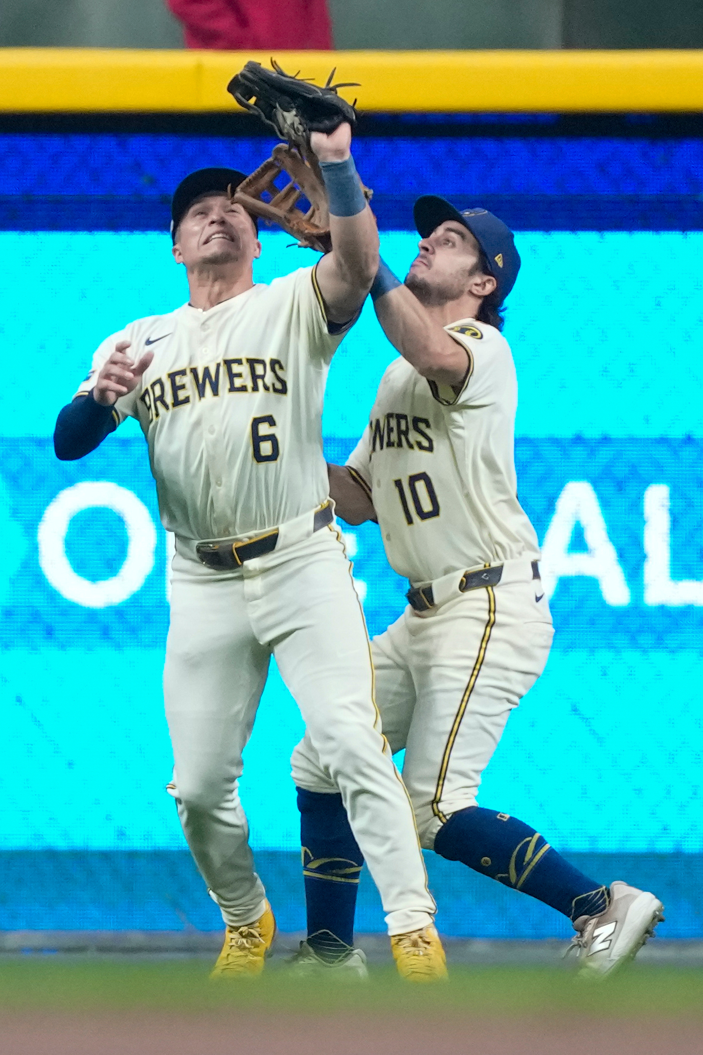Milwaukee Brewers center fielder Sal Frelick, right, collides with left...