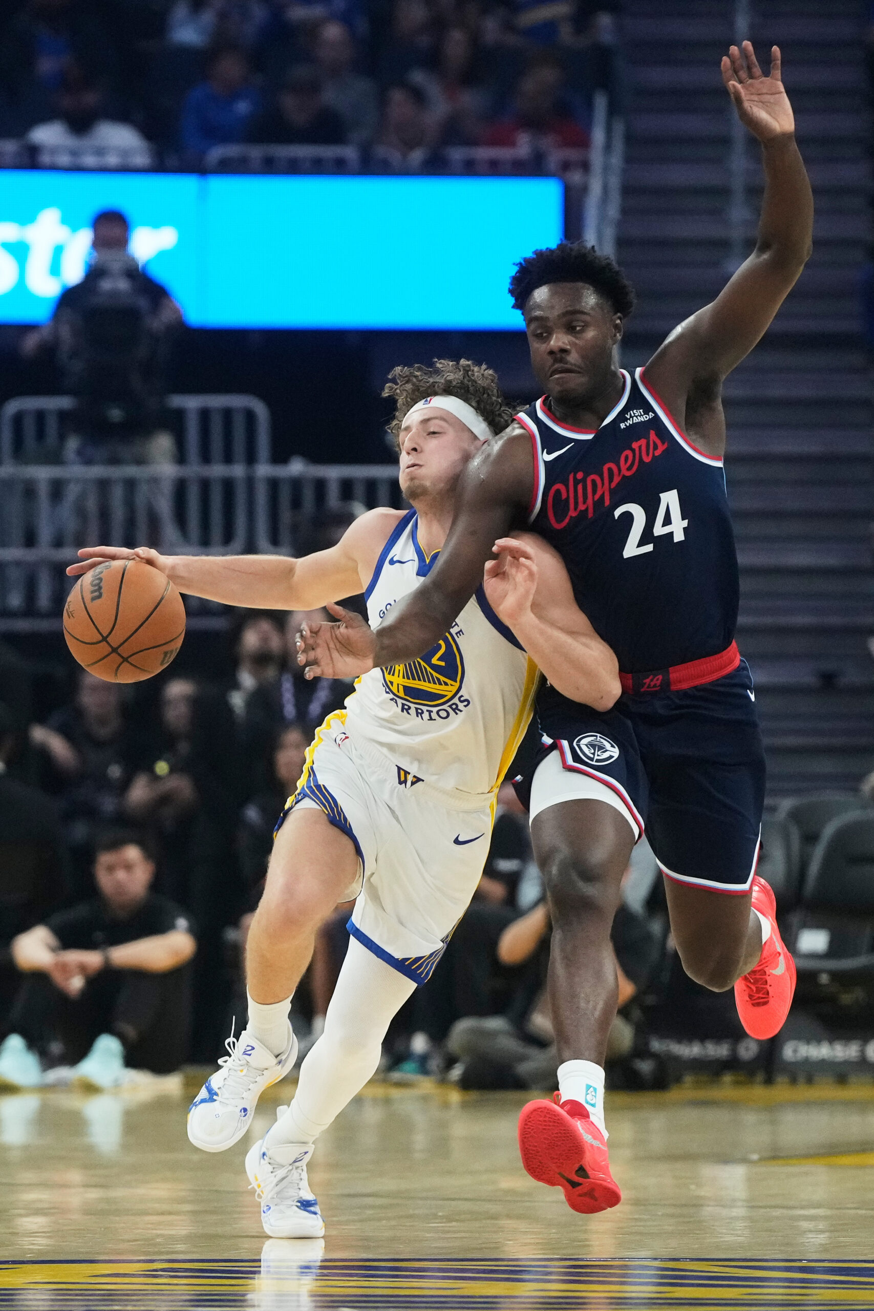 Golden State Warriors guard Brandin Podziemski, left, collides with Clippers...