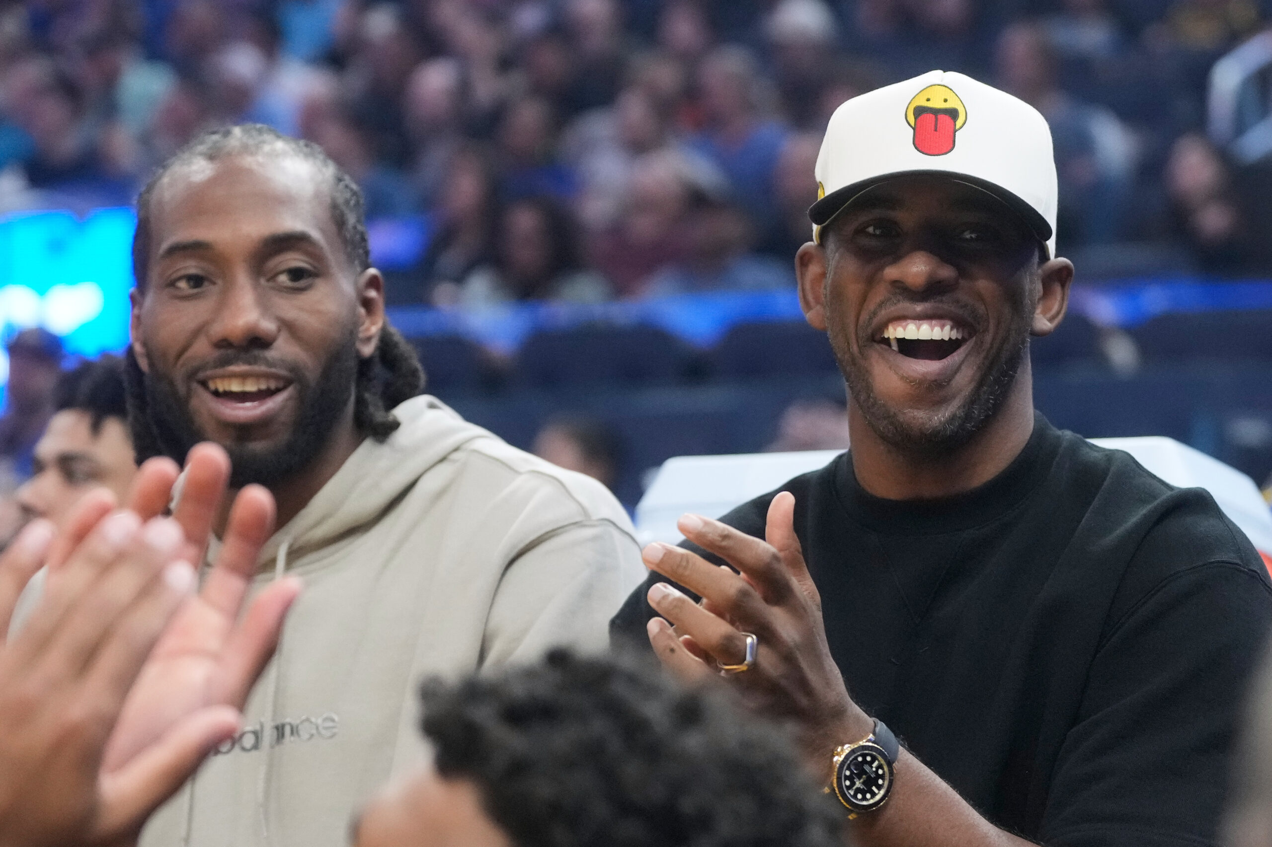 Clippers guard Chris Paul, right, smiles on the bench next...