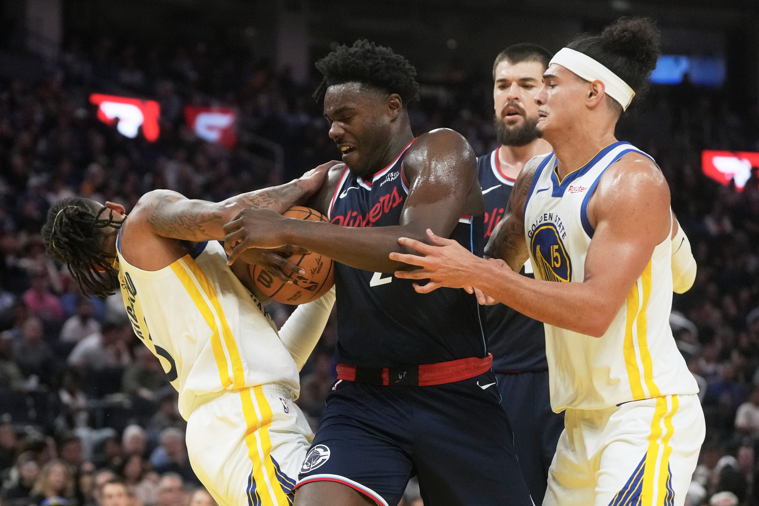 Clippers forward Kobe Brown, middle, tries to control the ball...
