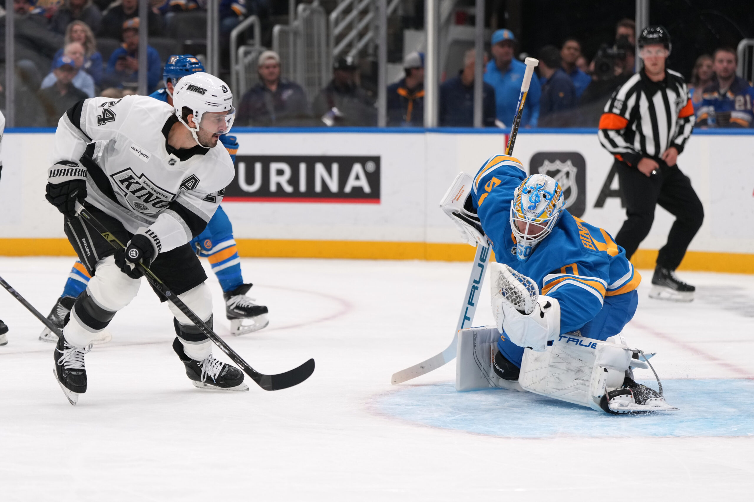 St. Louis Blues goaltender Jordan Binnington, right, stops a shot...