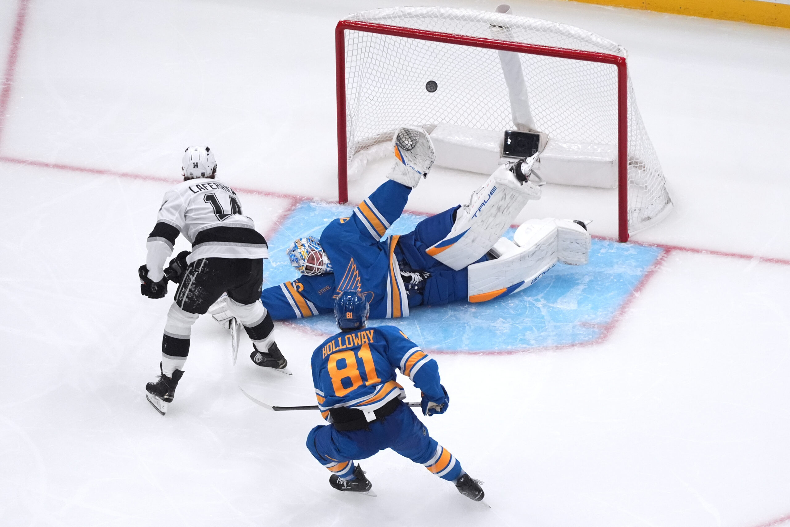 The Kings’ Alex Laferriere (14) scores past St. Louis Blues...