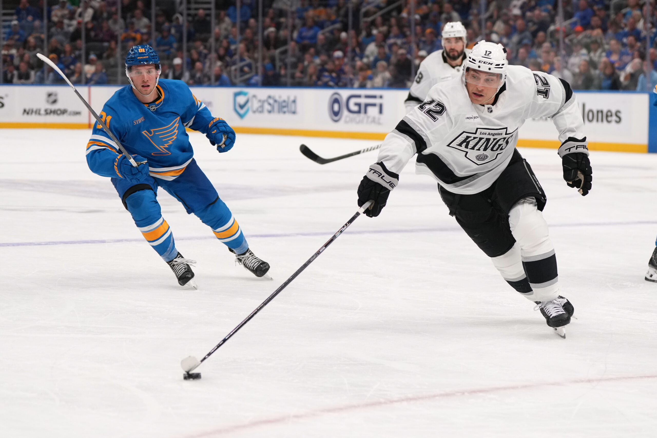 The Kings’ Trevor Moore (12) reaches for a loose puck...