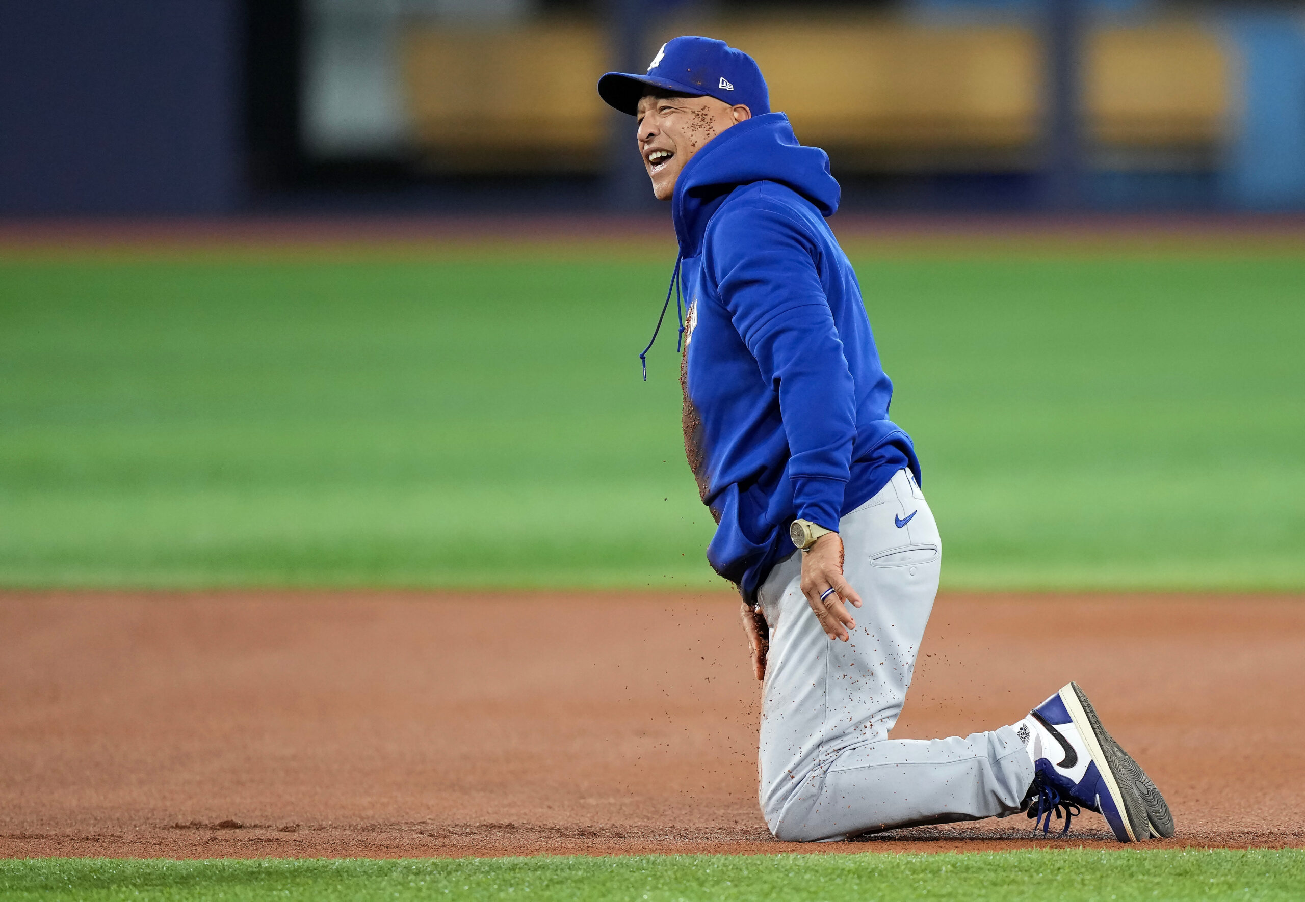 Dodgers manager Dave Roberts reacts after wiping out and falling...