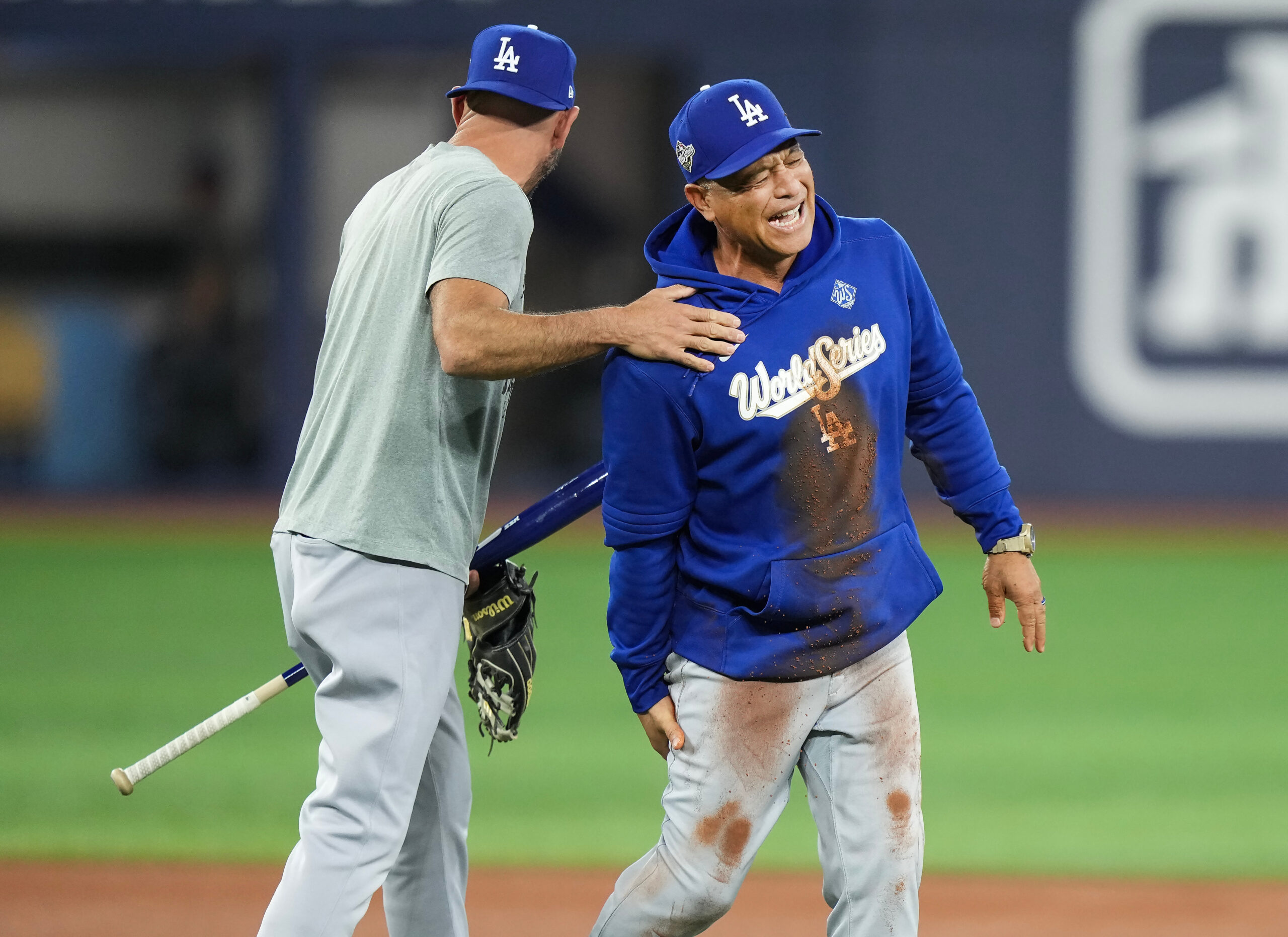 Dodgers manager Dave Roberts, right, fakes a hamstring injury after...