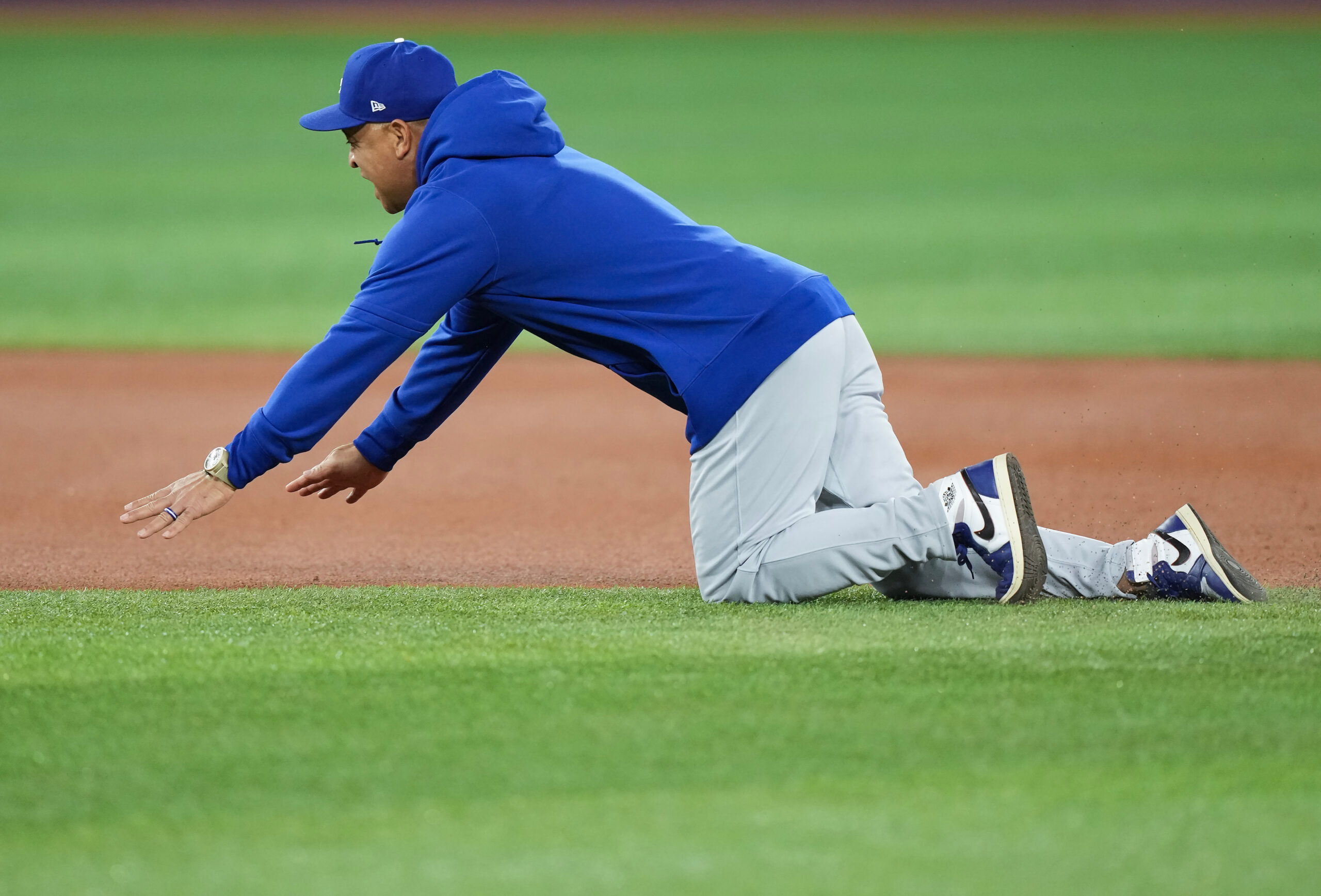 Dodgers manager Dave Roberts wipes out and falls to the...