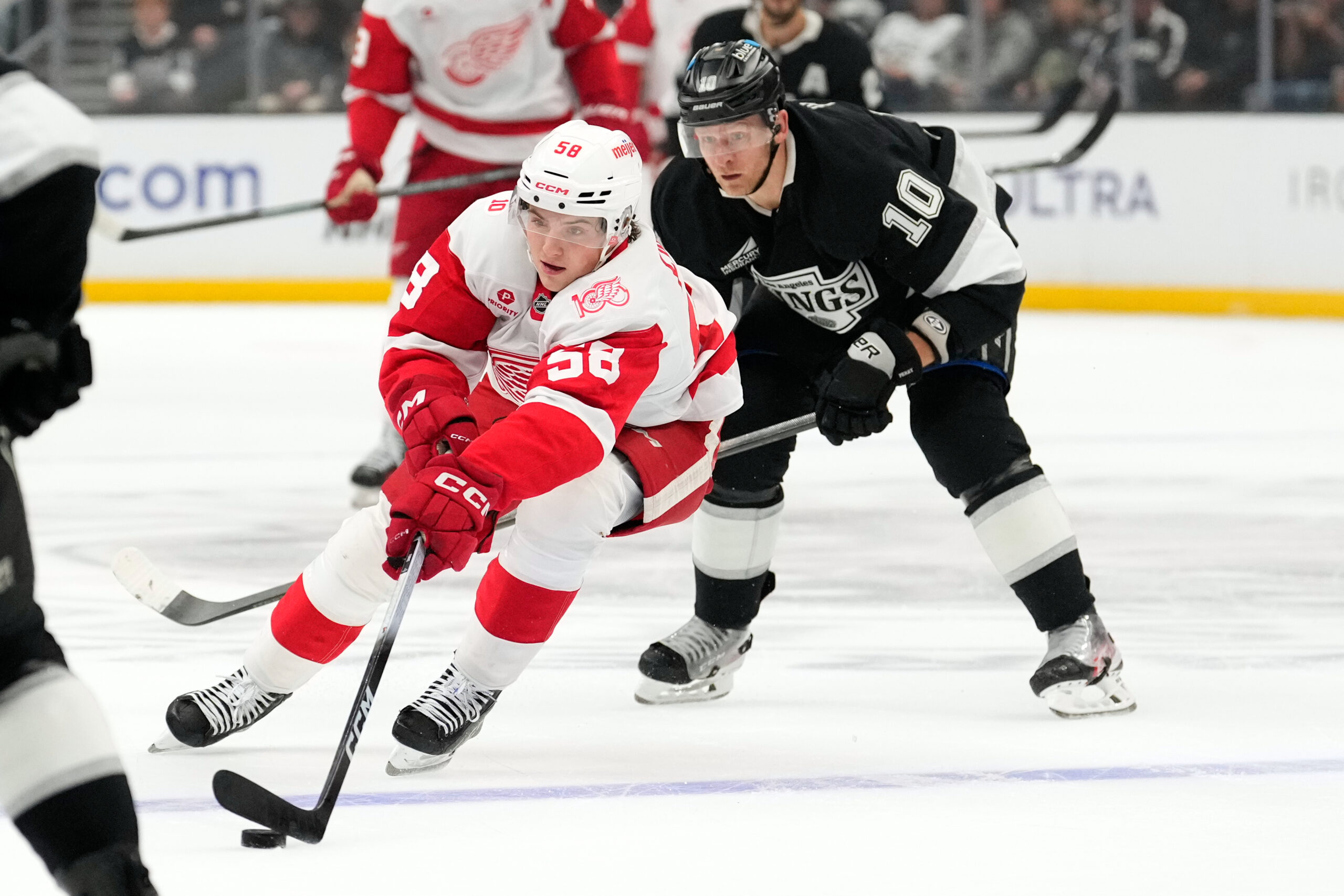 Detroit Red Wings center Emmitt Finnie, left, controls the puck...