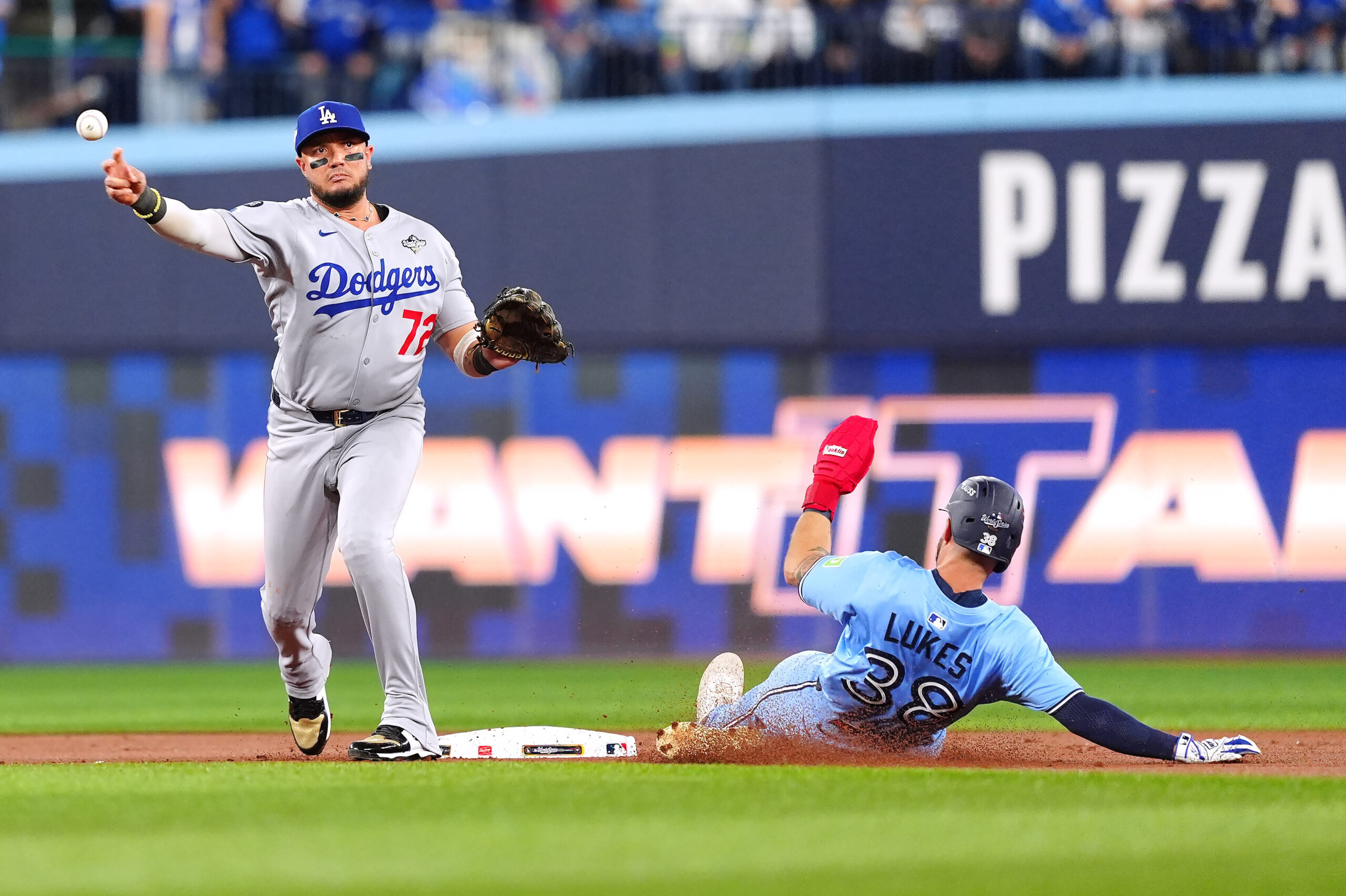 Dodgers second baseman Miguel Rojas throws to first base to...